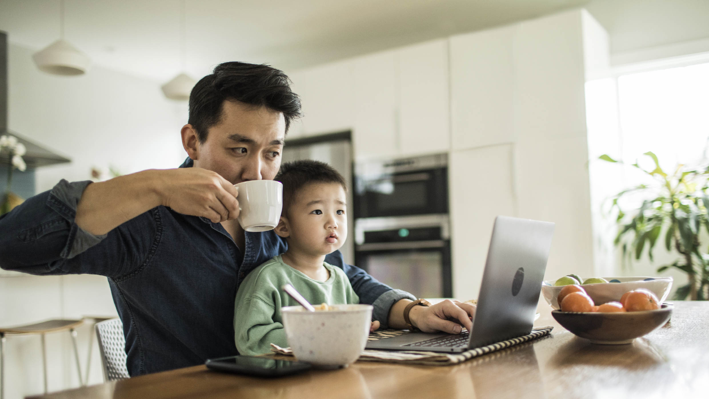 Father and son at kitchen table on laptop