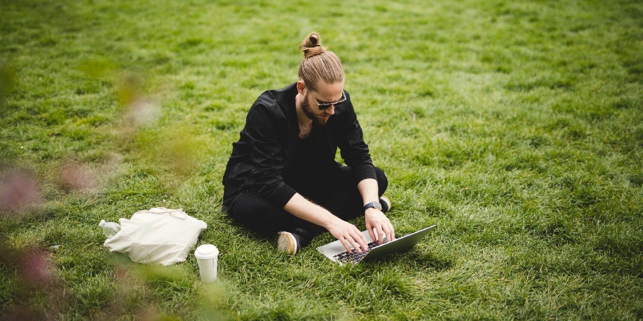Man using a laptop in a park