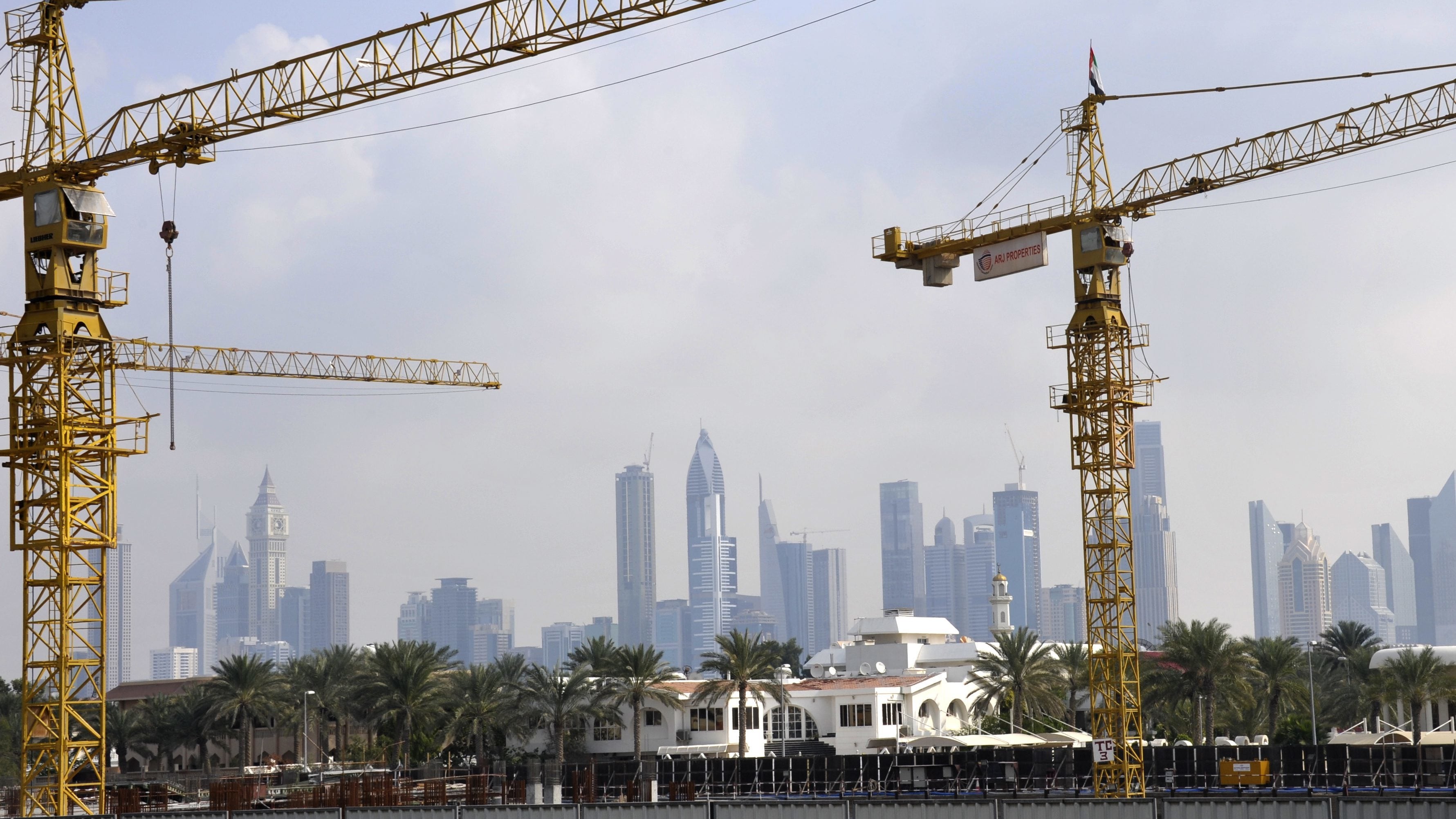 Cranes in front of the skyscraper skyline of Dubai