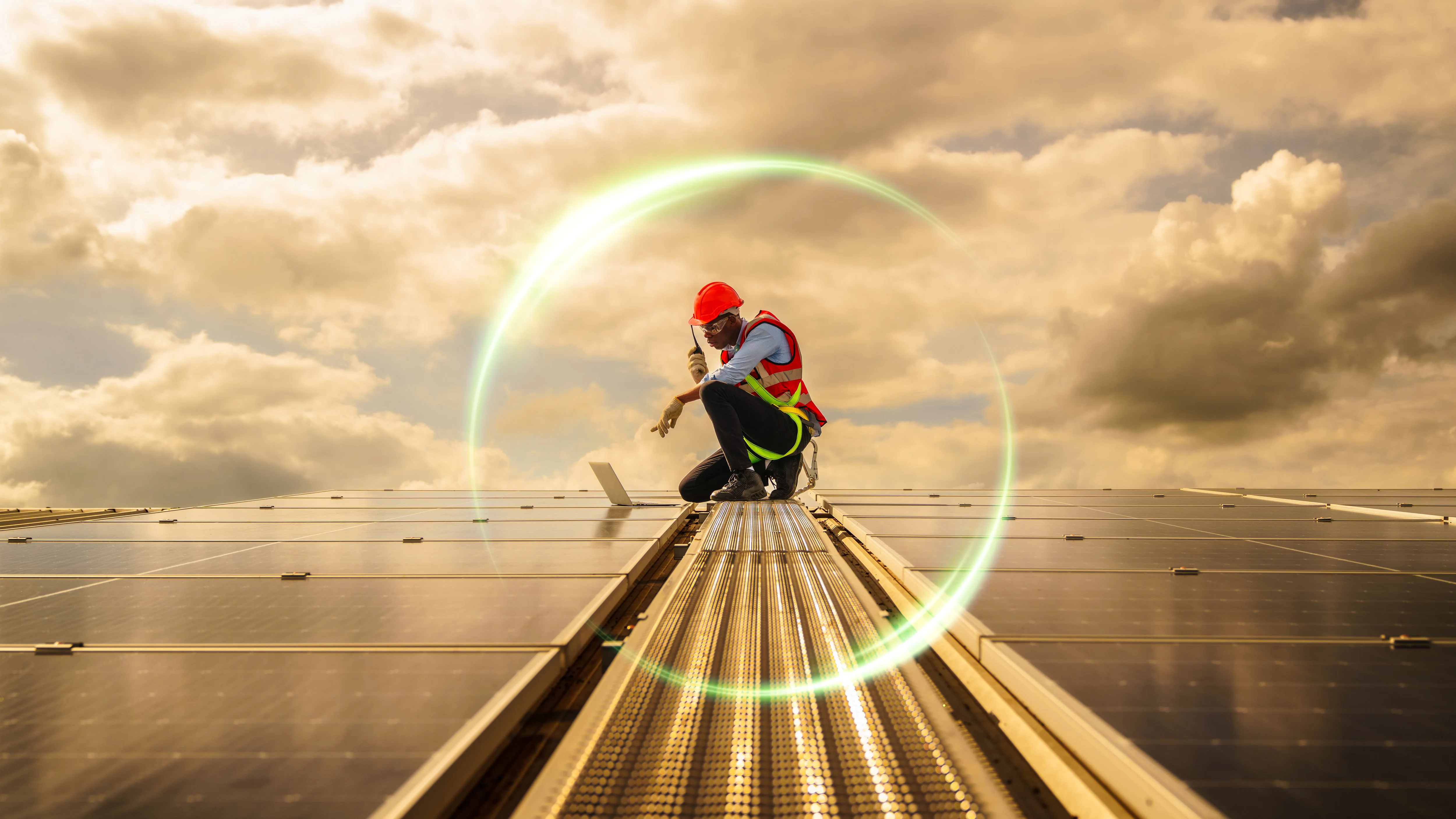 Engineer on solar panels under clouds with lens flare