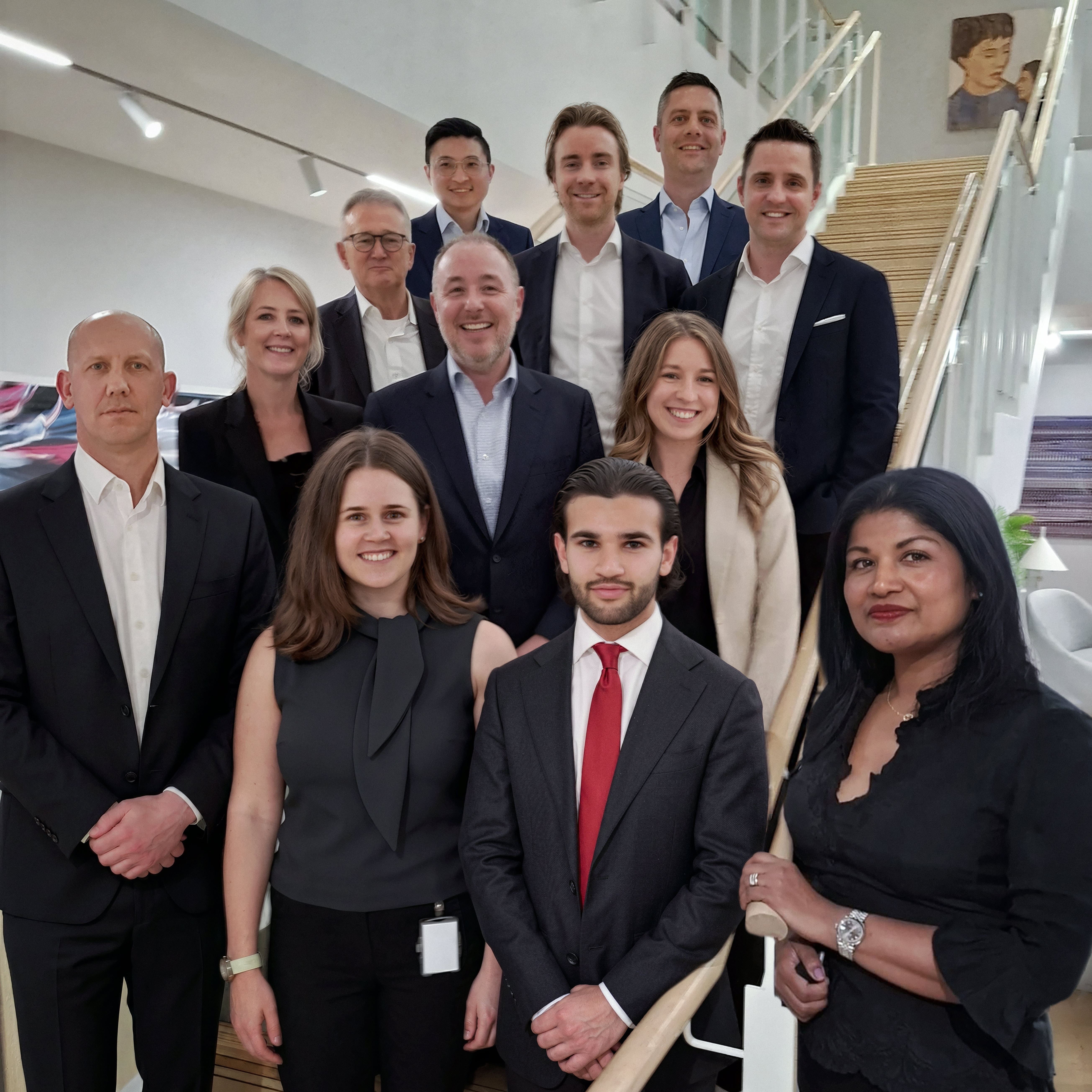 AIRMIC 2026 A group of twelve people in business attire poses on a staircase in a modern interior.