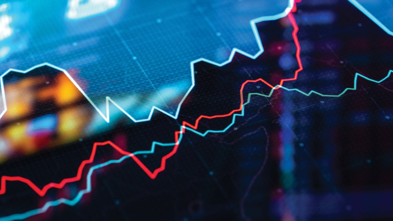 Digital Stock Market Graph Analysis A close-up of a digital financial chart displaying red and green lines on a dark background.