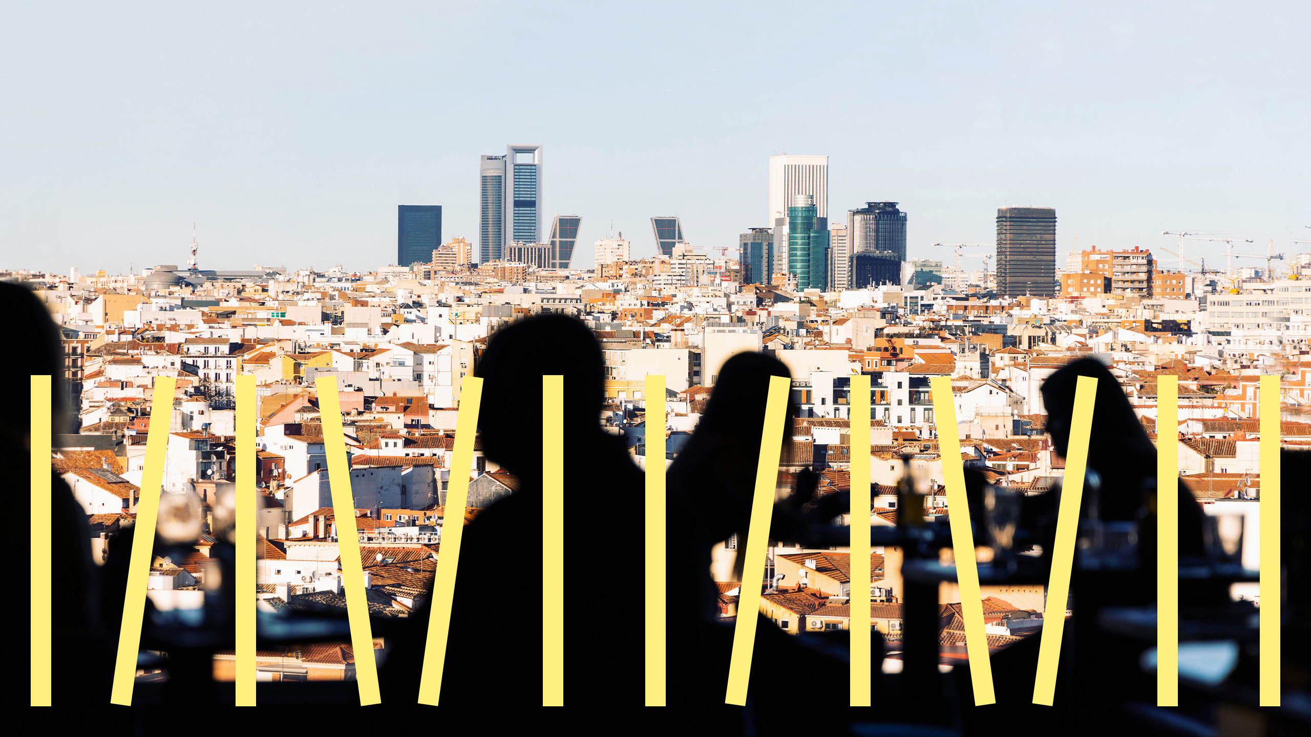 Munich Re Madrid Silhouettes of people dining indoors with a city skyline view featuring modern buildings in the background.