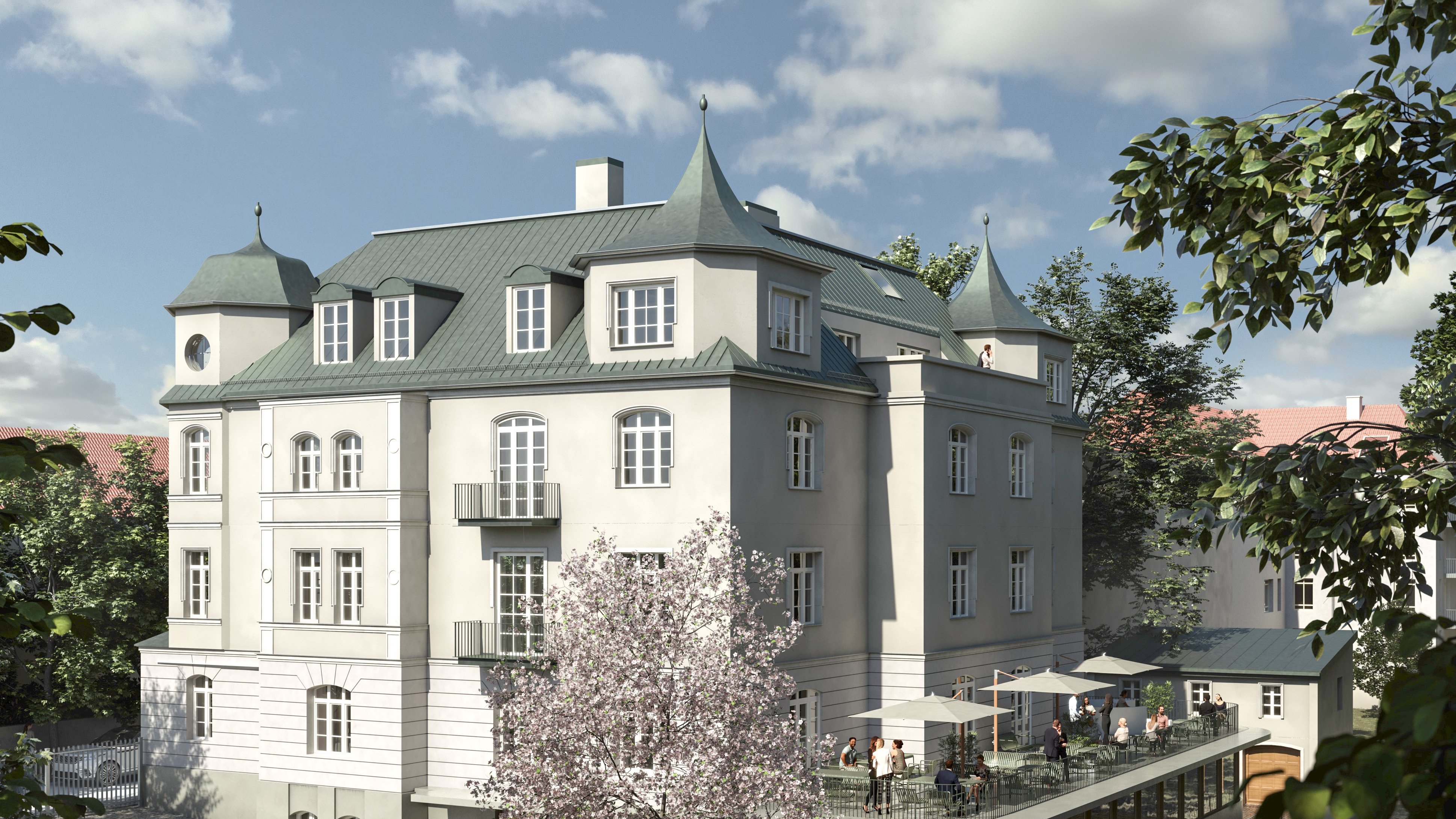 Ein modernes Gebäude mit grünen Dächern, Balkonen und einer Terrasse, umgeben von Bäumen und blühenden Pflanzen.