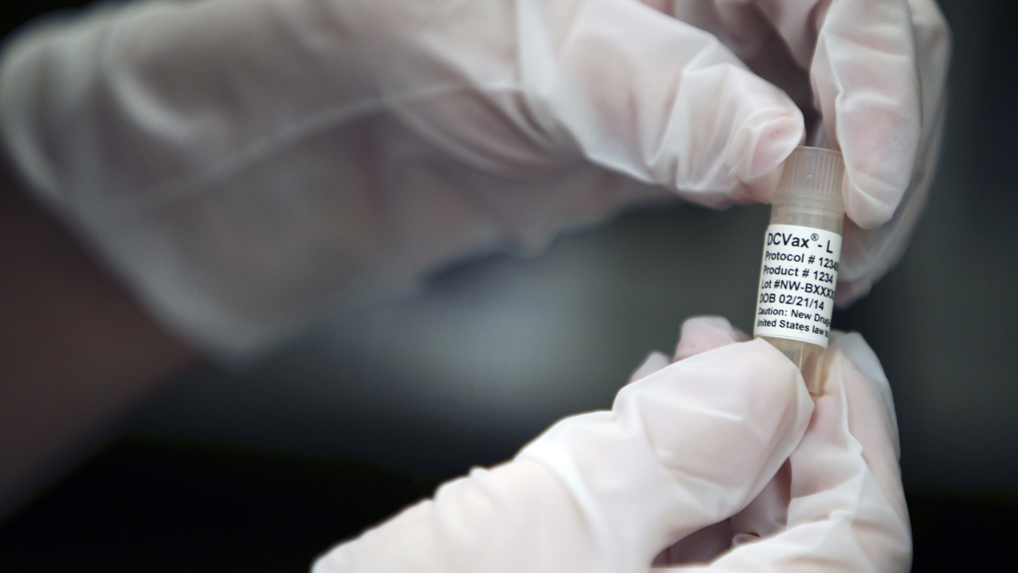 A manufacturing associate holds a vial with a DCVax-L label in a Northwest Biotherapeutics laboratory in Memphis