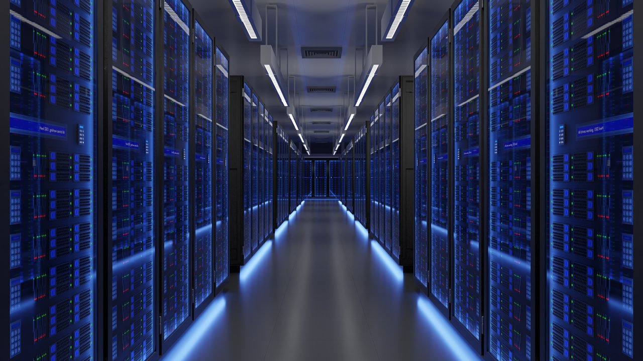 A corridor lined with server racks, illuminated by blue lights, in a data center.