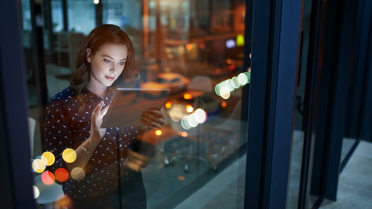 Cropped shot of a young businesswoman working late on a digital tablet in an office