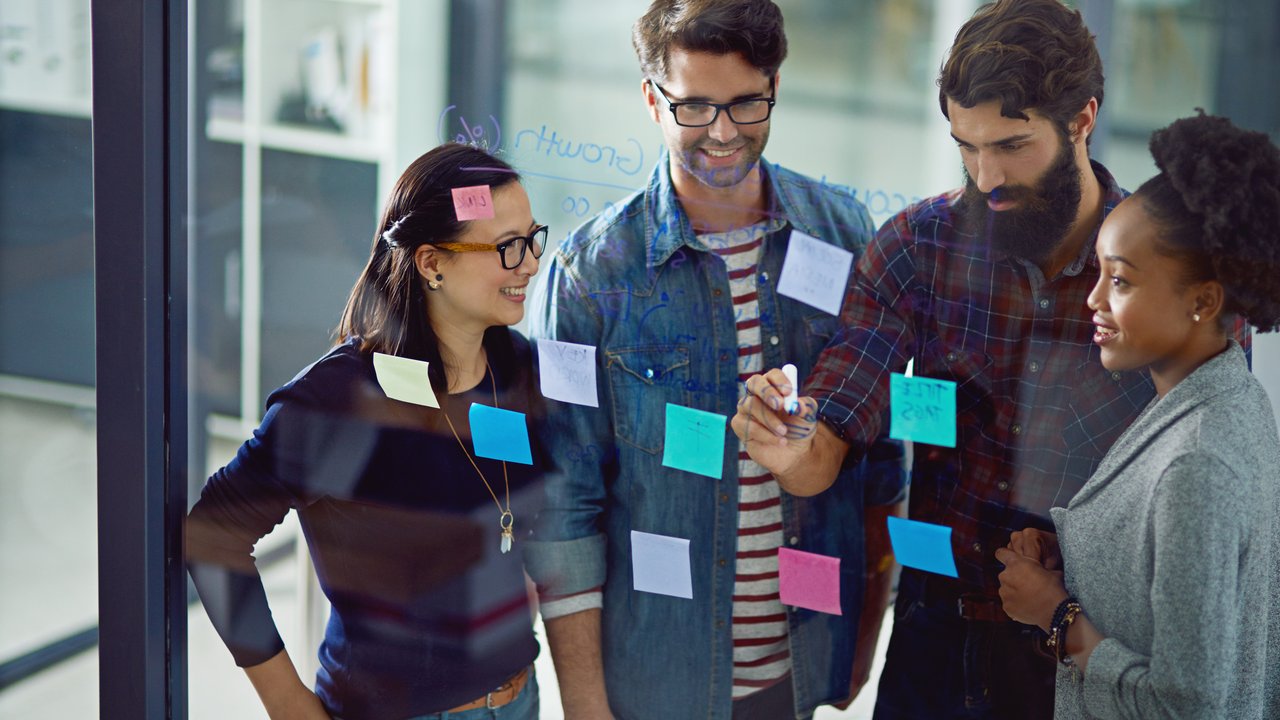 Business people working on a glass wall looking over their notes for the challenges in the life insurance industry