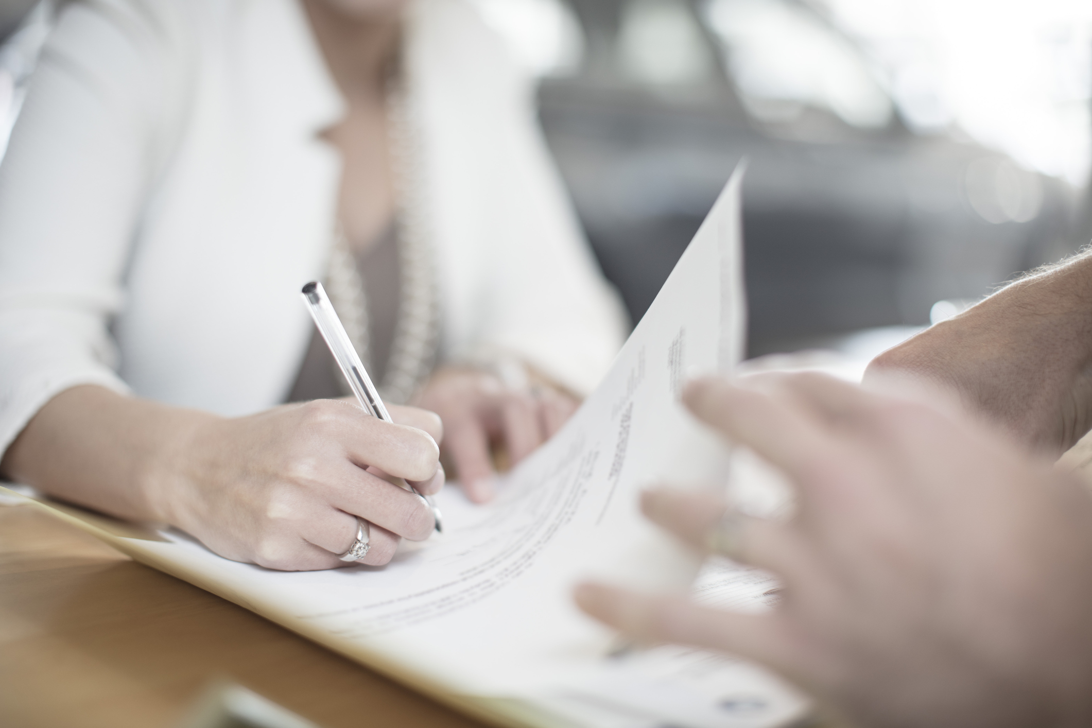 Close-up image of paperwork being signed