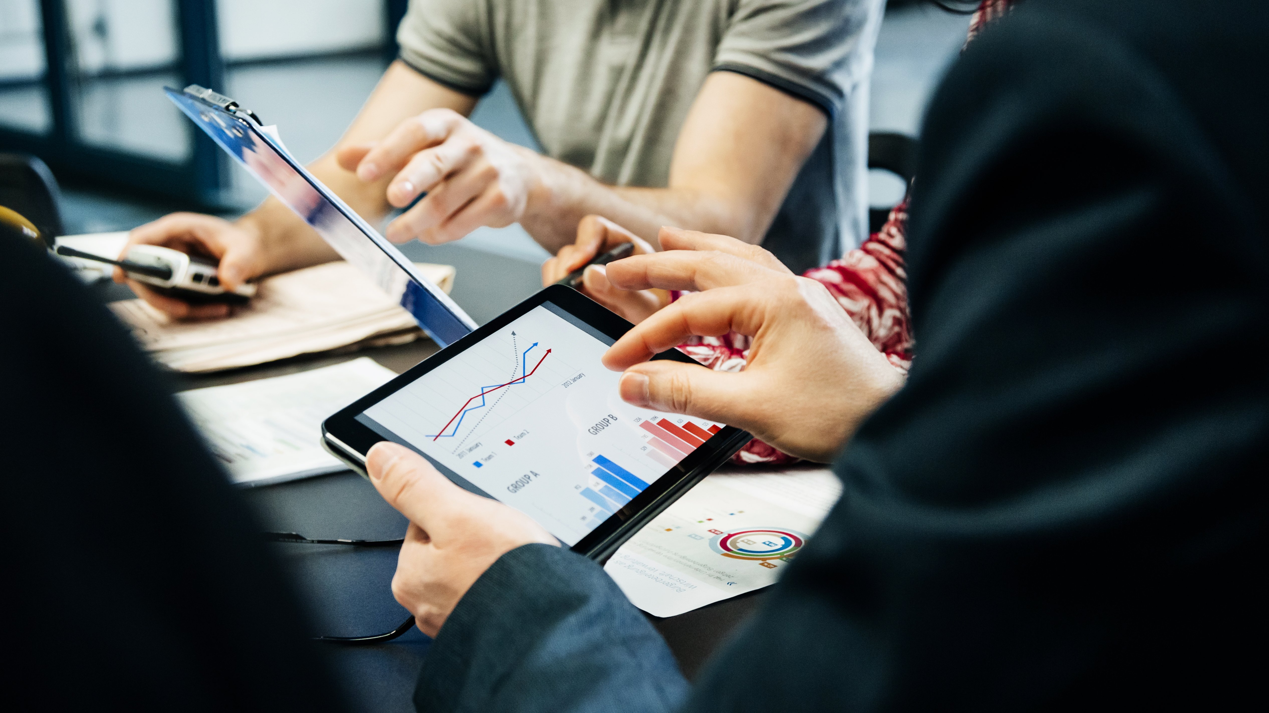 Life insurer survey: What types of fraud are trending upward? Business team holding a meeting and looking at the data from the life insurance survey on fraud trends on digital tablets