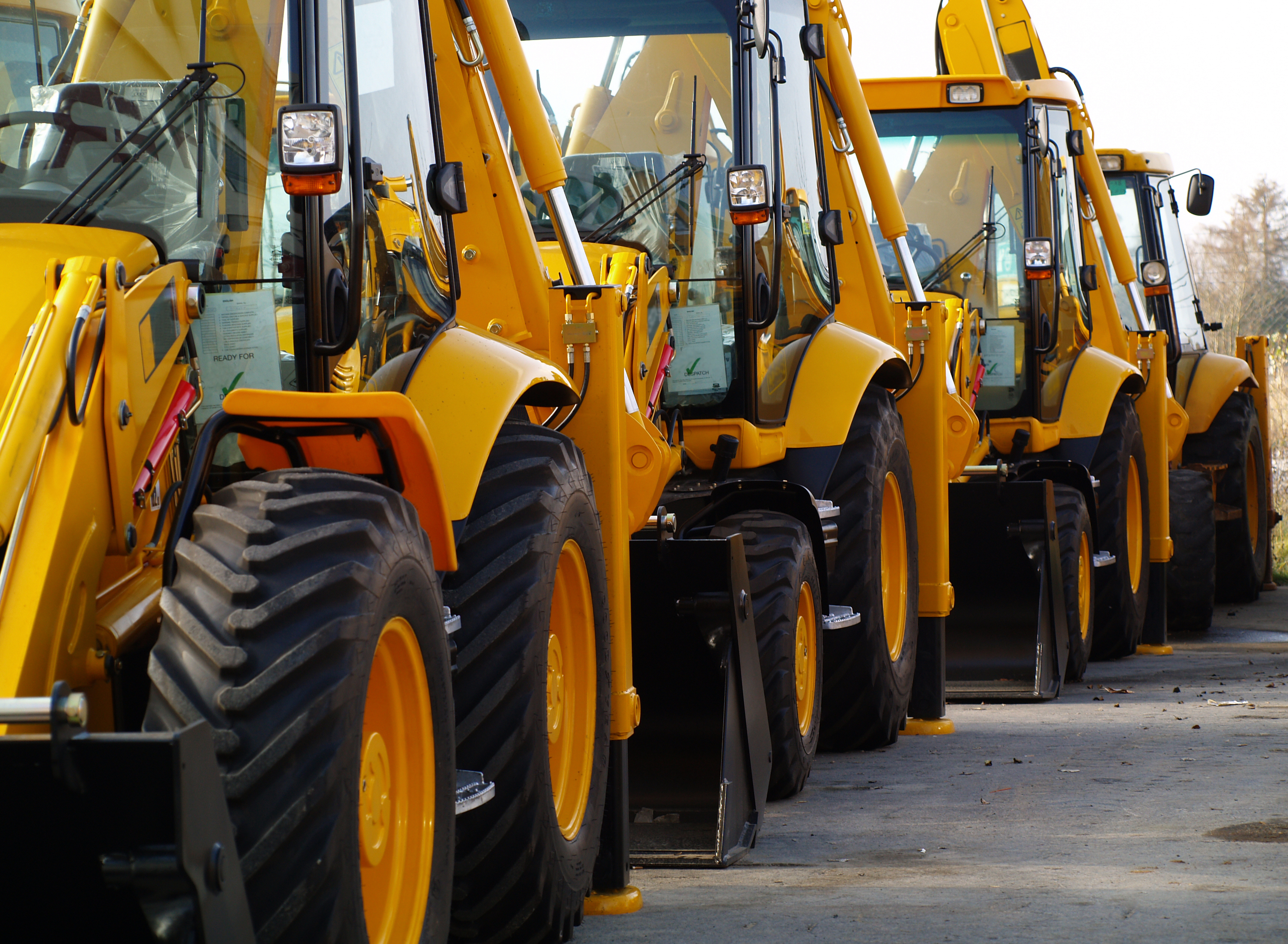 Diggers in a row in an industrial car park