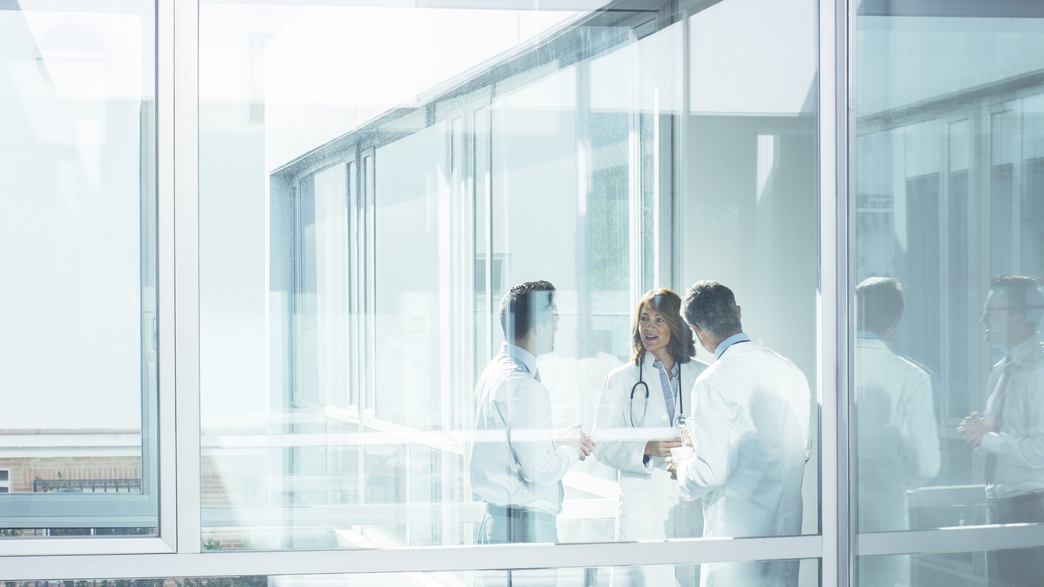 Doctors and administrator in office corridor