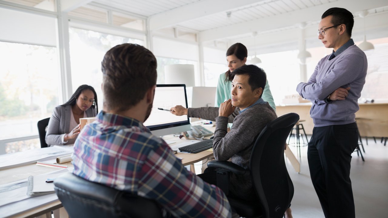 Architects meeting working at computer in office