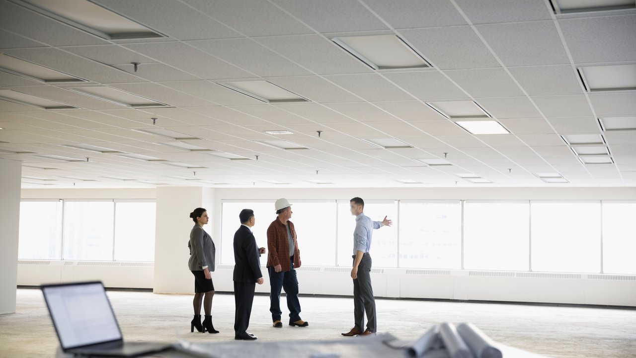 Contractor and architects working in unfinished, empty open plan office