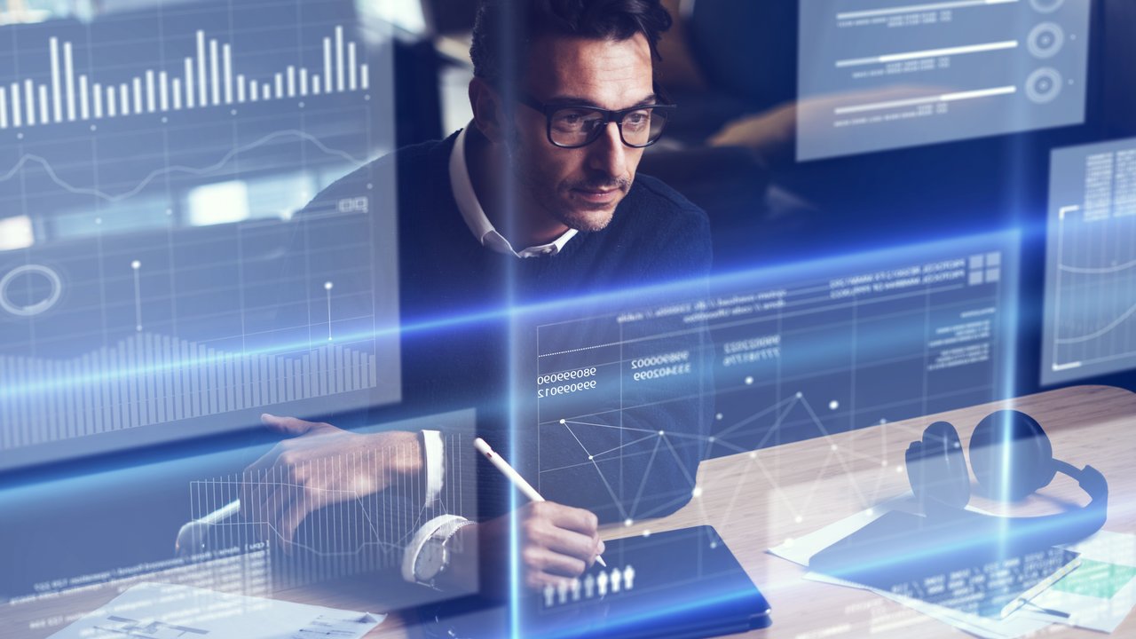 Ein Data Analytics-Experte sitzt am Schreibtisch und arbeitet mit Daten