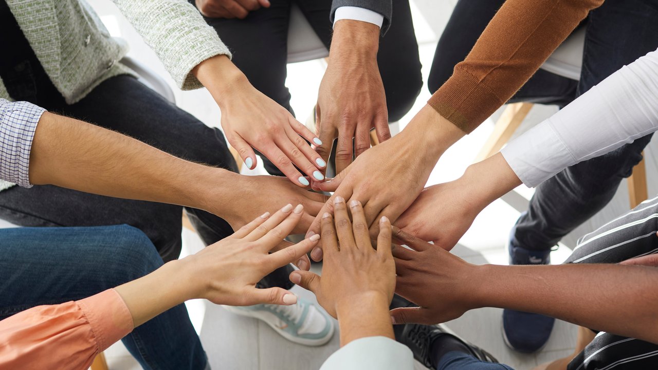 Challenging risks test relationships of cedents, reinsurers Closeup banner of diverse people stack hands