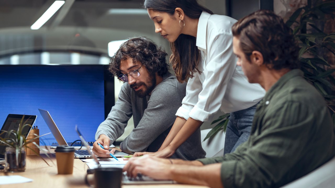 Colleagues discussing business strategy in open office