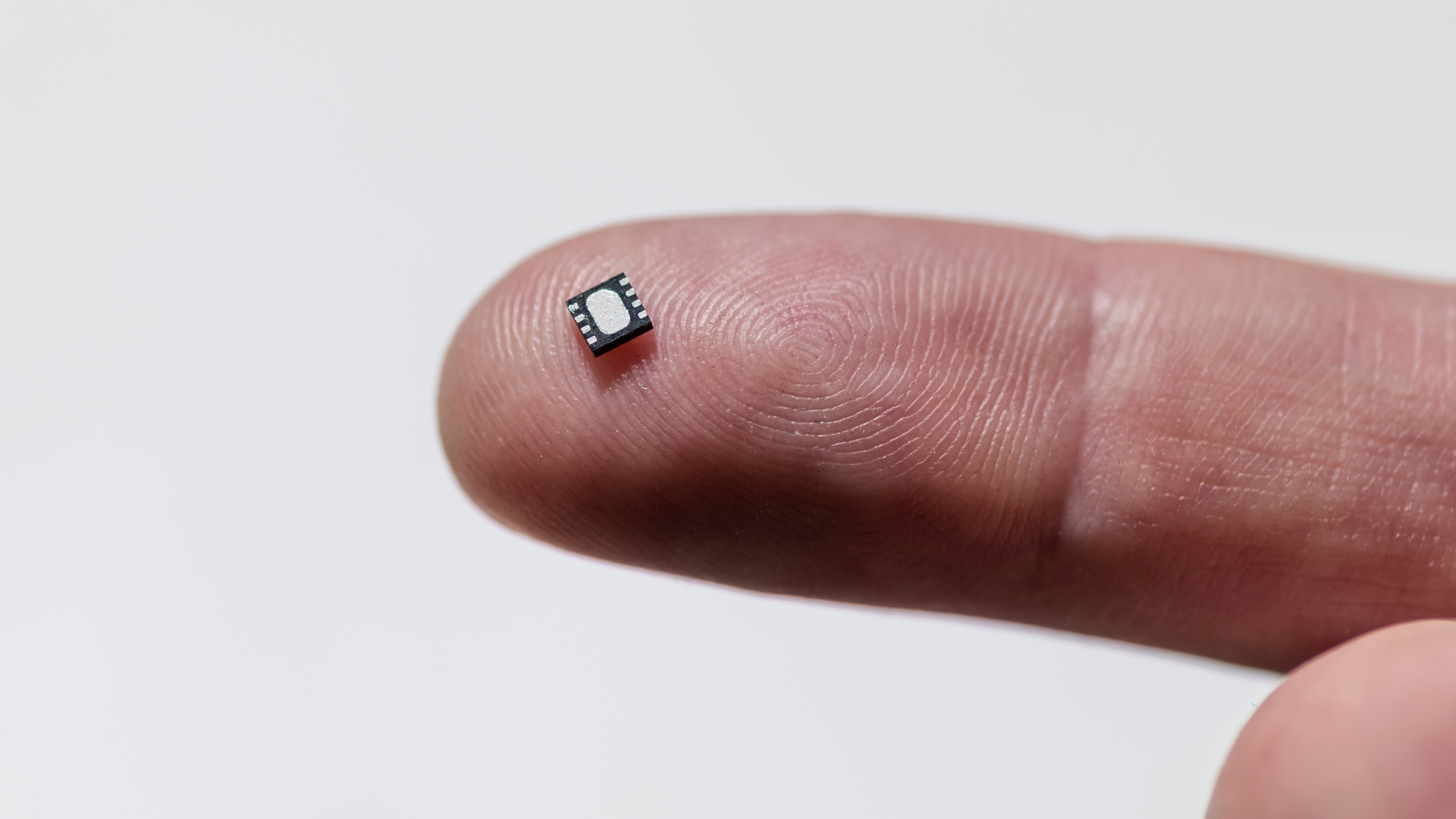 Close up of electronic microchip on human finger