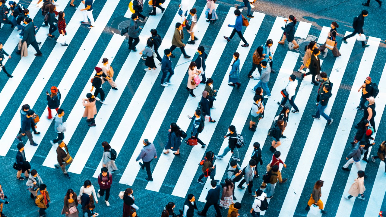 Top view of pedestrians intersecting the famous Shibuya crossing in Tokyo.