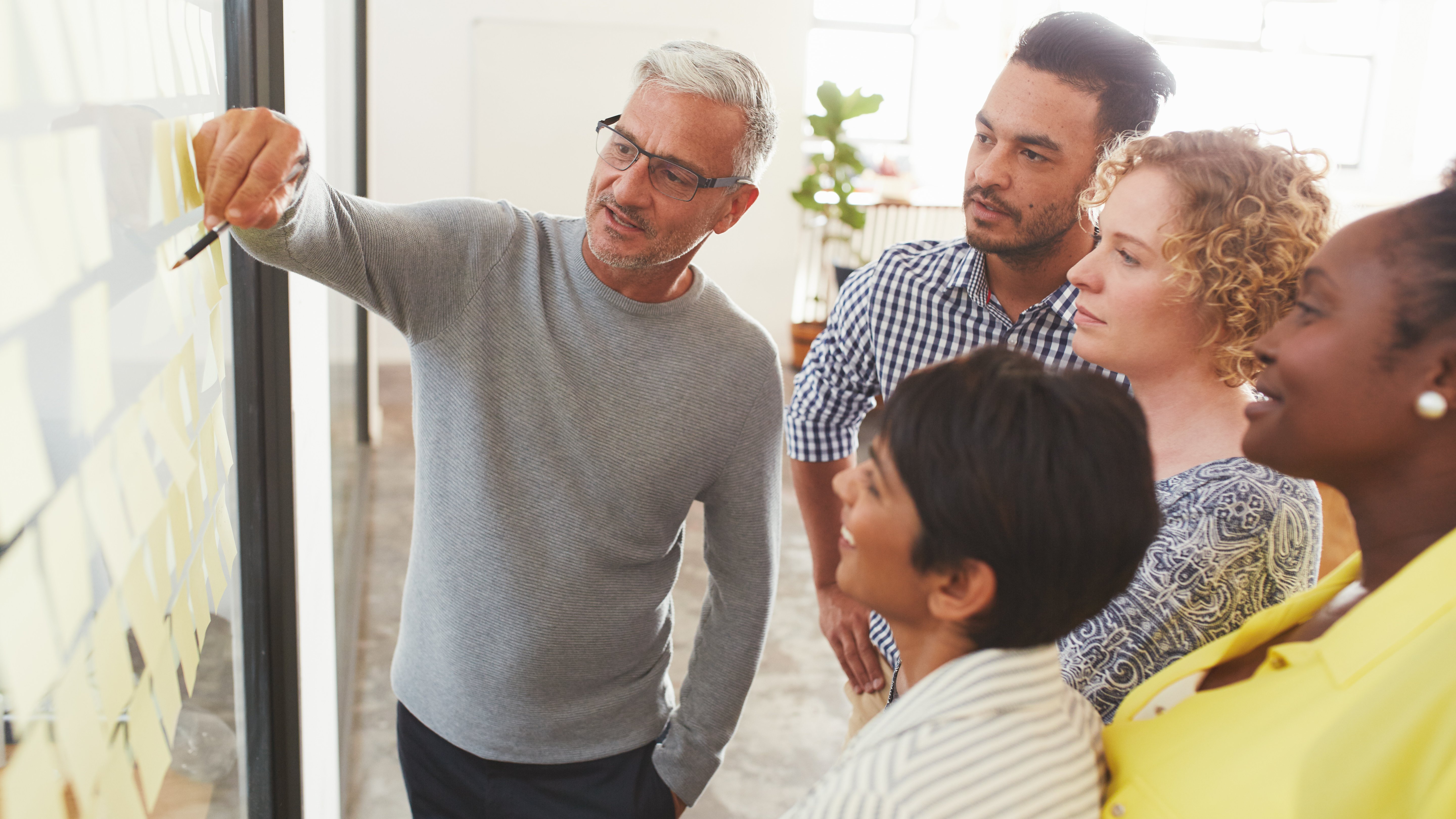 Diverse businesspeople brainstorming with adhesive notes in a meeting