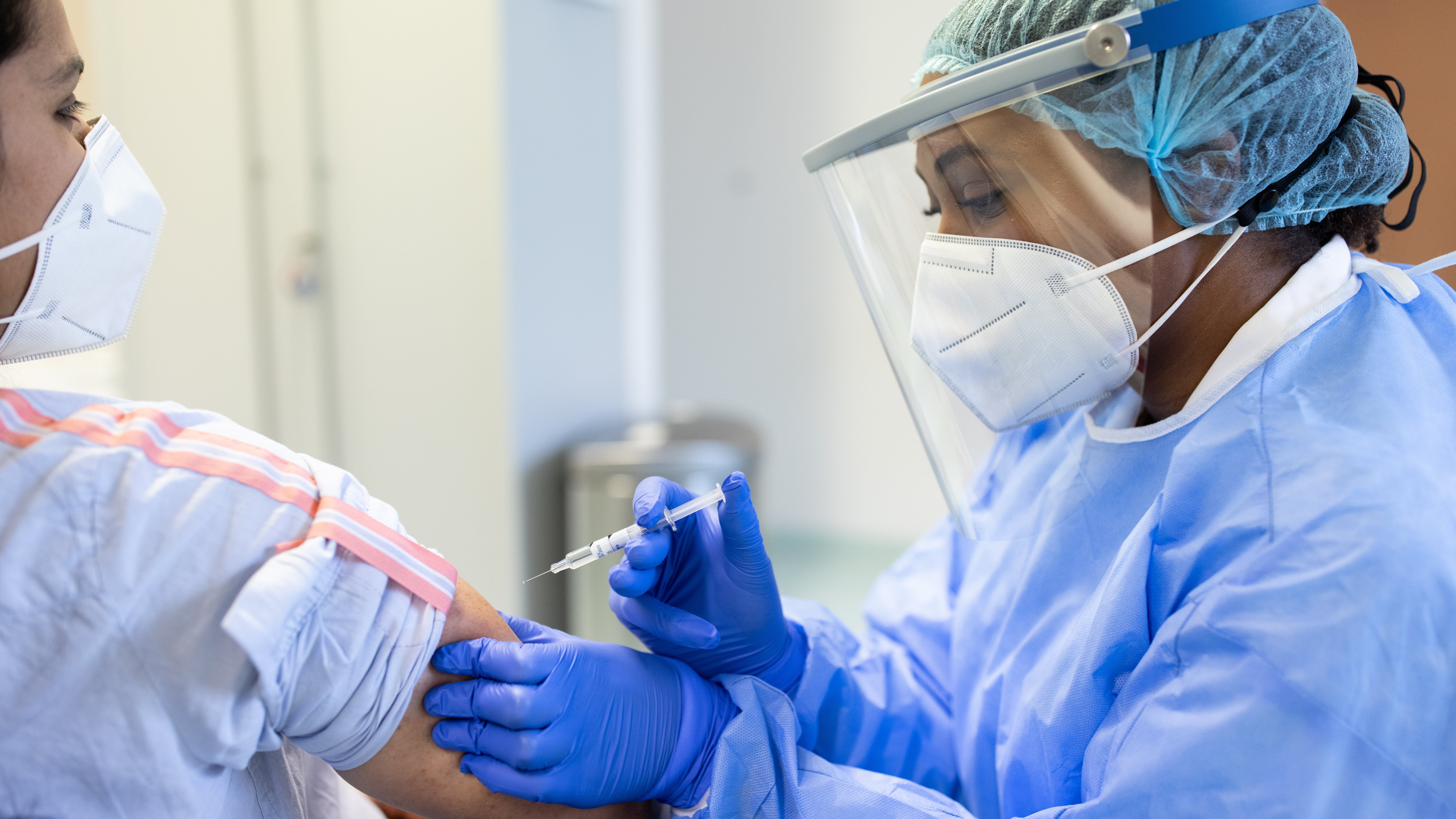 Autoimmune diseases following COVID-19 infection: How solid is the evidence? Doctor in personal protective equipment vaccinating a patient for COVID19