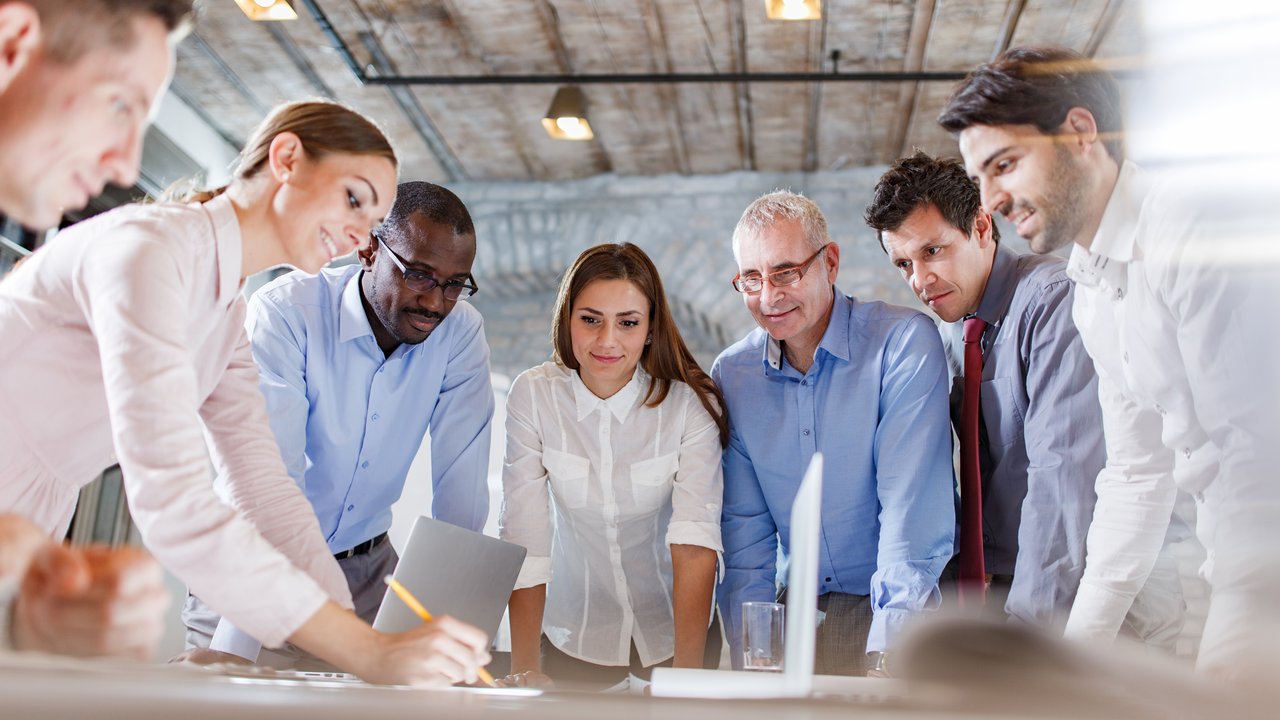 Seven businesspeople working together in a team meeting to discuss their product development cycle