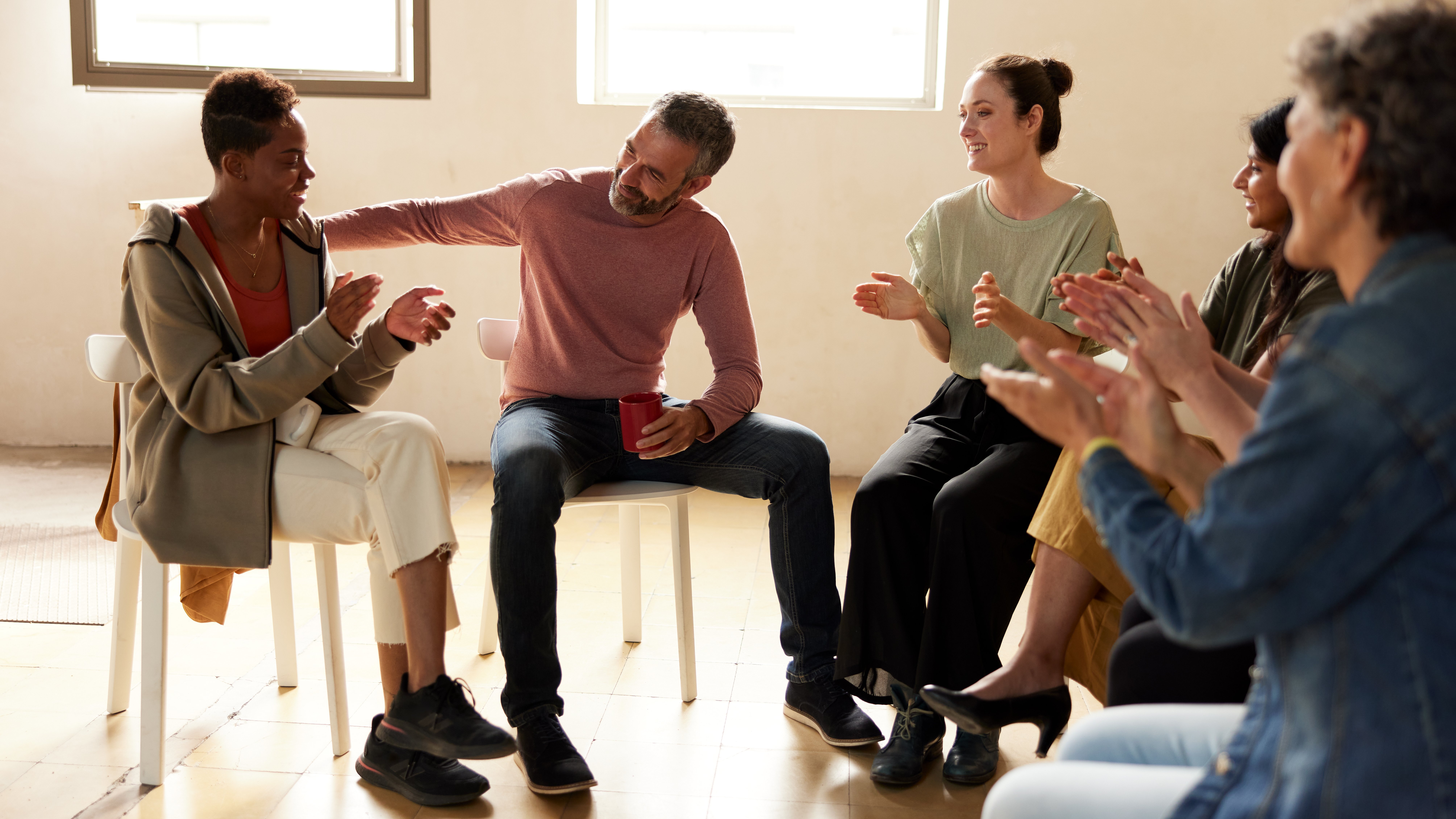 Members of group therapy clap after a member talked about their mental illness