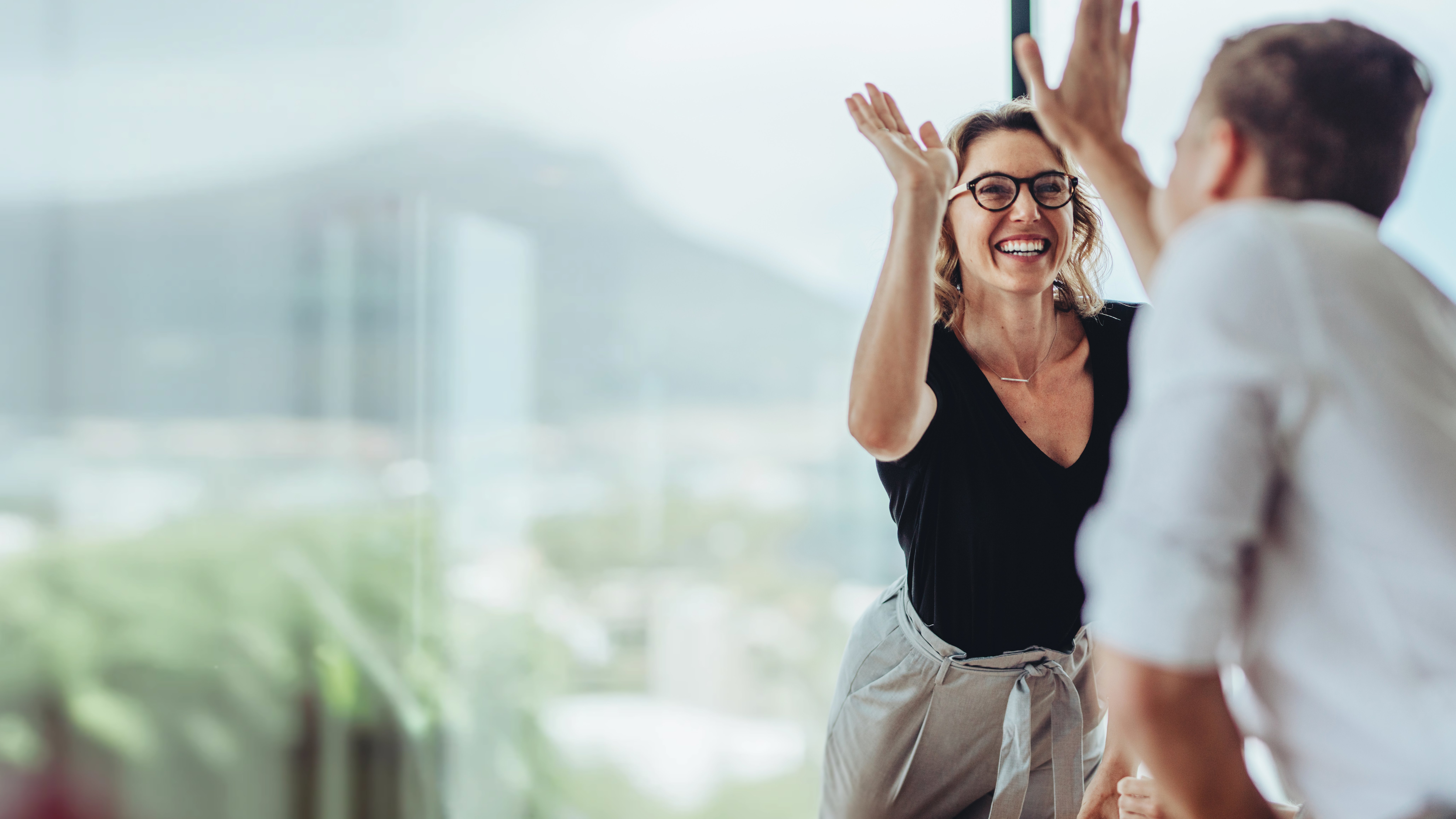Businesswoman giving a high five to male colleague in meeting