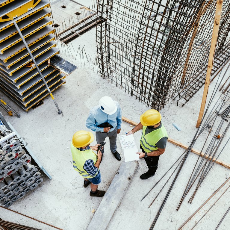 Engineers and contractor going over plans on construction site