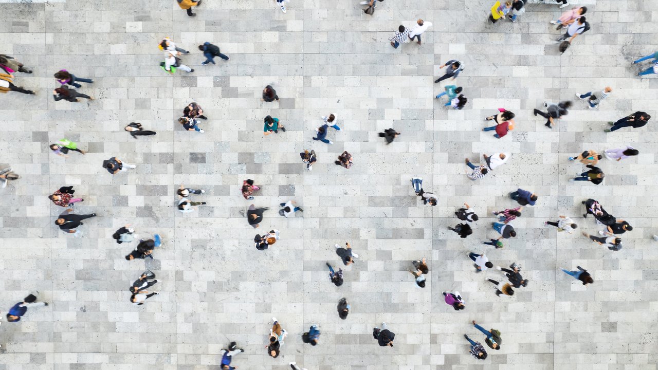 Disability insurance: New possibilities of evidence-based risk assessment Aerial view of a crowded plaza with many people walking on a stone pavement.
