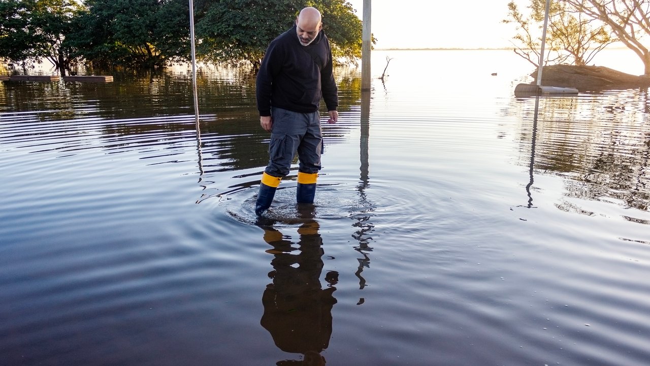 Man walking in flood water A man wearing rubber boots is walking in flood water.