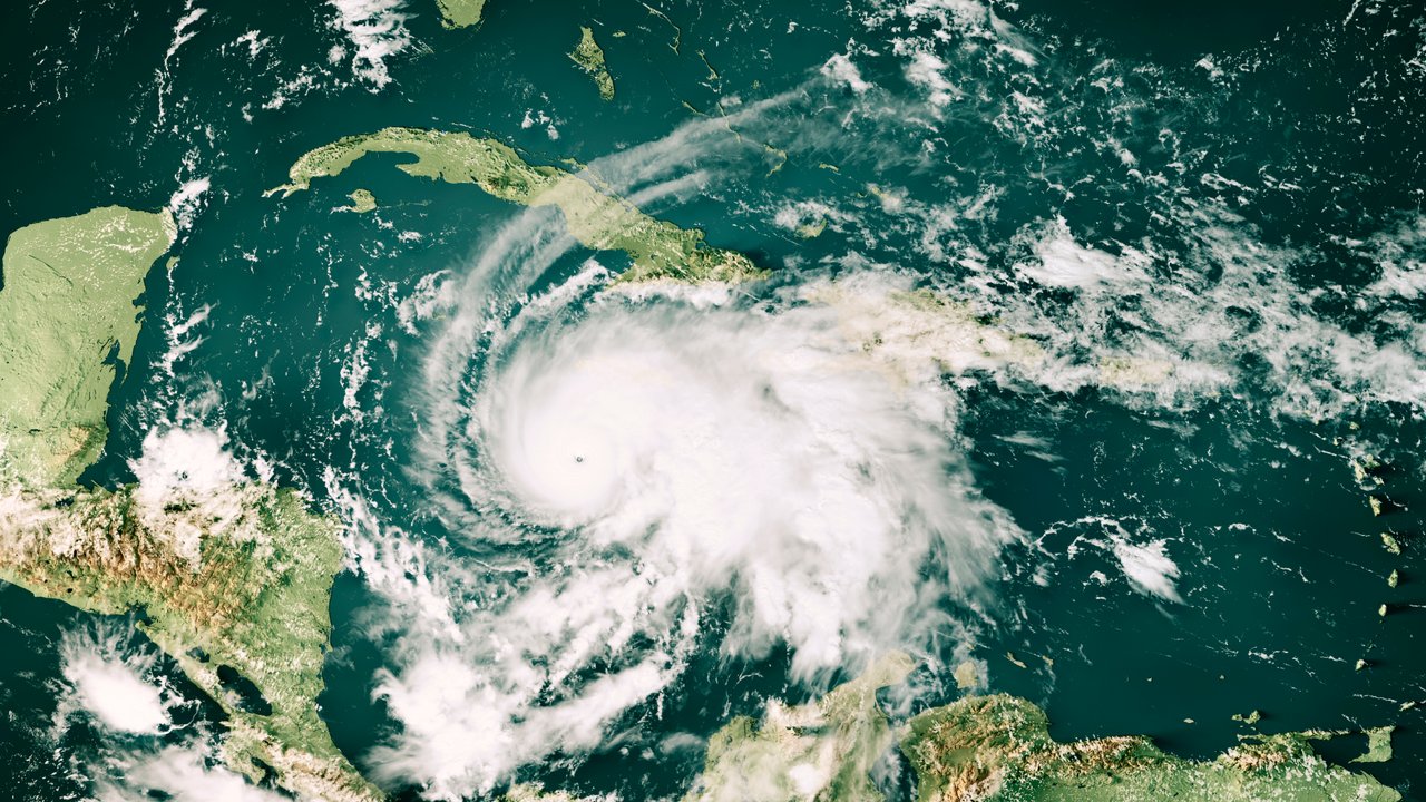 Satellite image of a hurricane over the Caribbean Sea, with visible landmasses of Central America and Cuba.