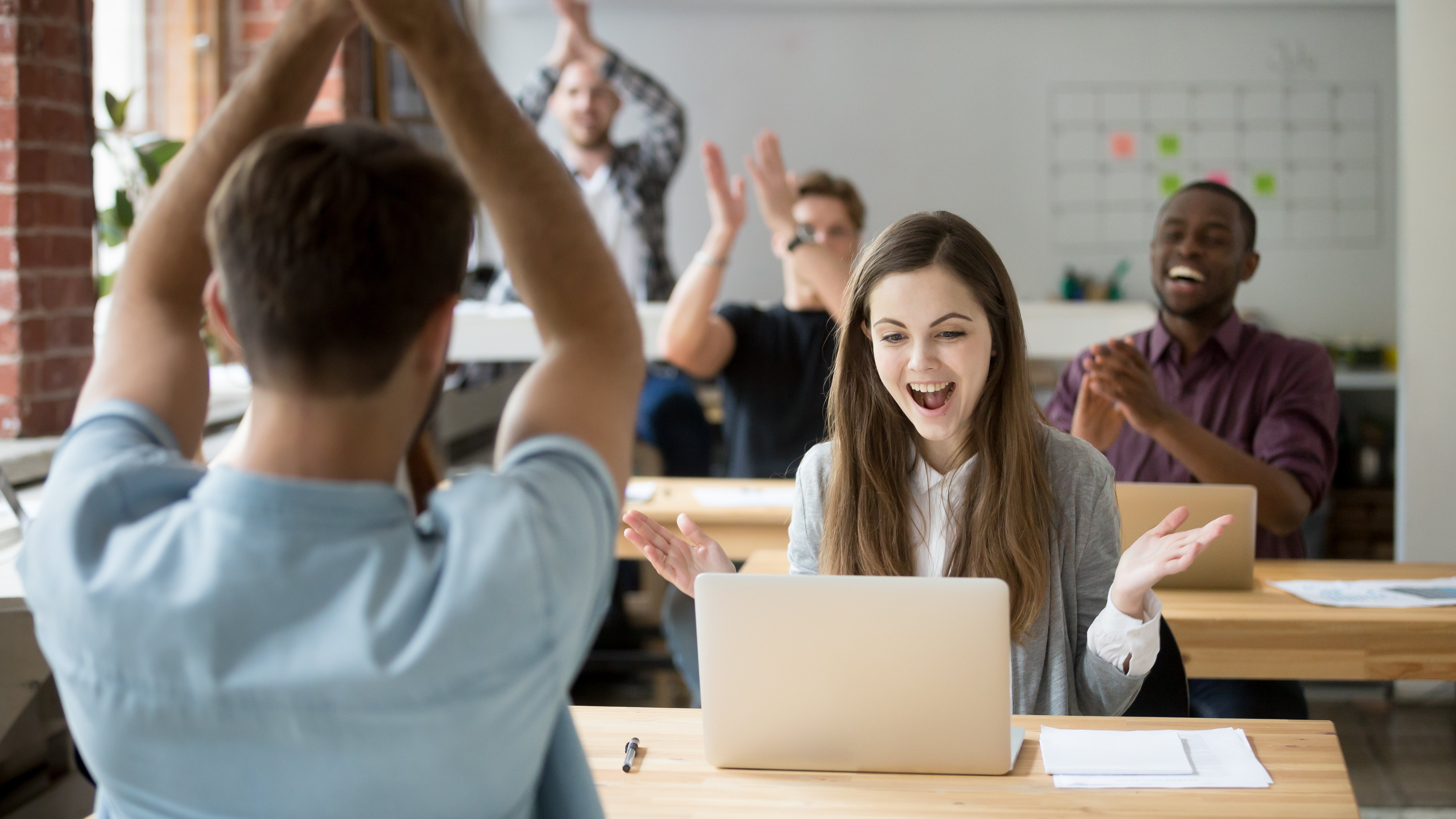 Professional team cheering on their colleague