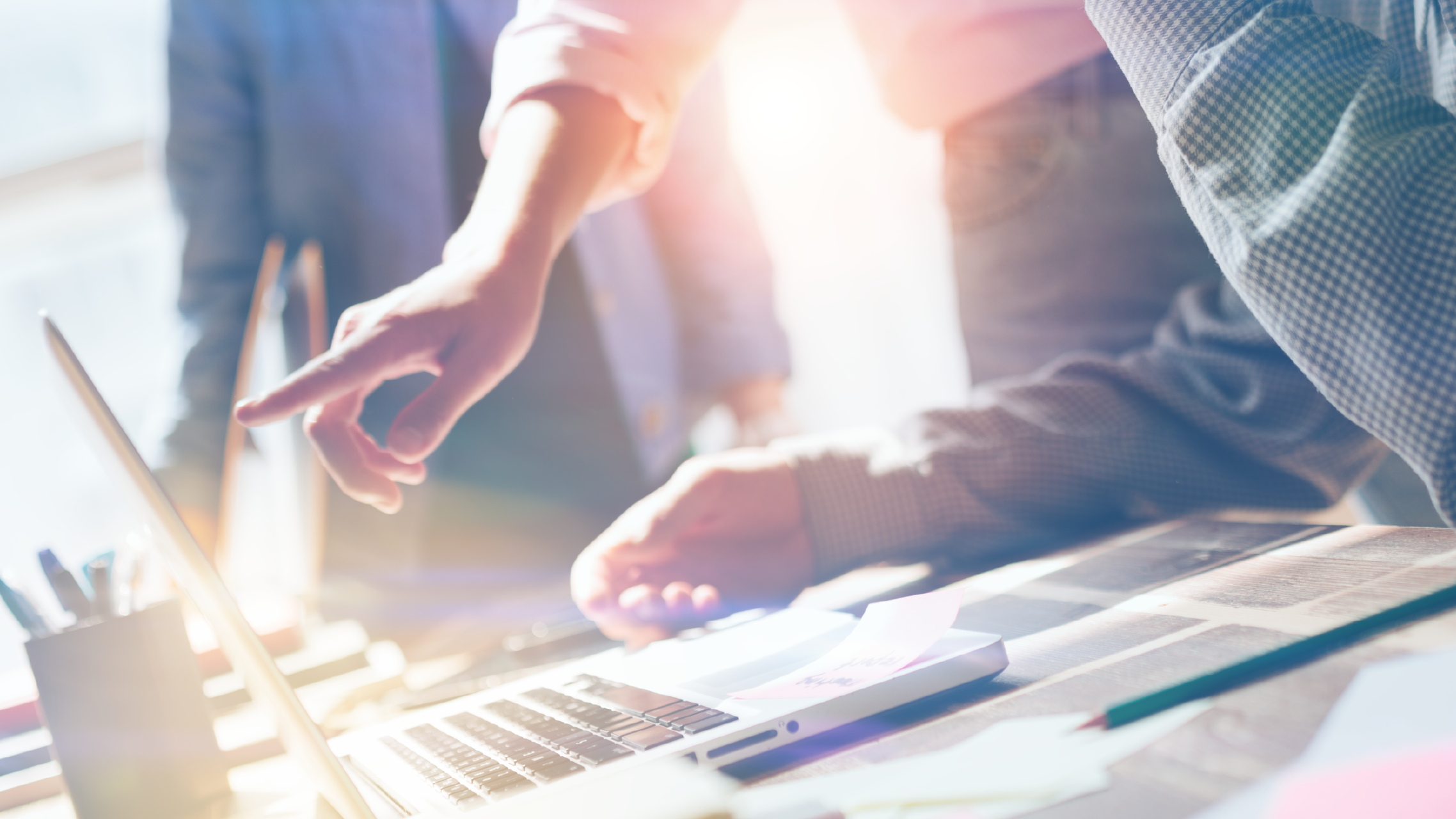 Trois personnes en réunion d’affaires utilisant un ordinateur portable