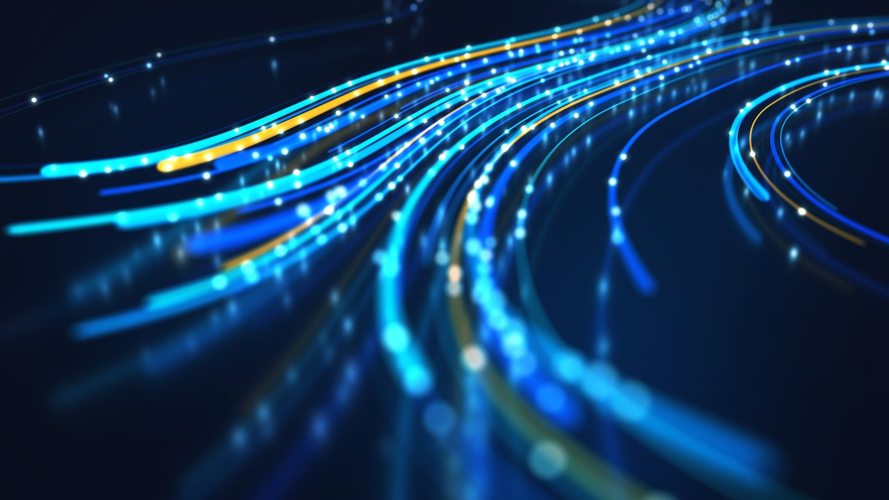 A dynamic composition of glowing lines in shades of blue, accented with hints of yellow, flows across a dark background. The lines vary in thickness and brightness, creating a sense of movement and depth. Small, bright dots intermittently punctuate the lines, enhancing the visual rhythm and evoking a feeling of energy and connectivity.