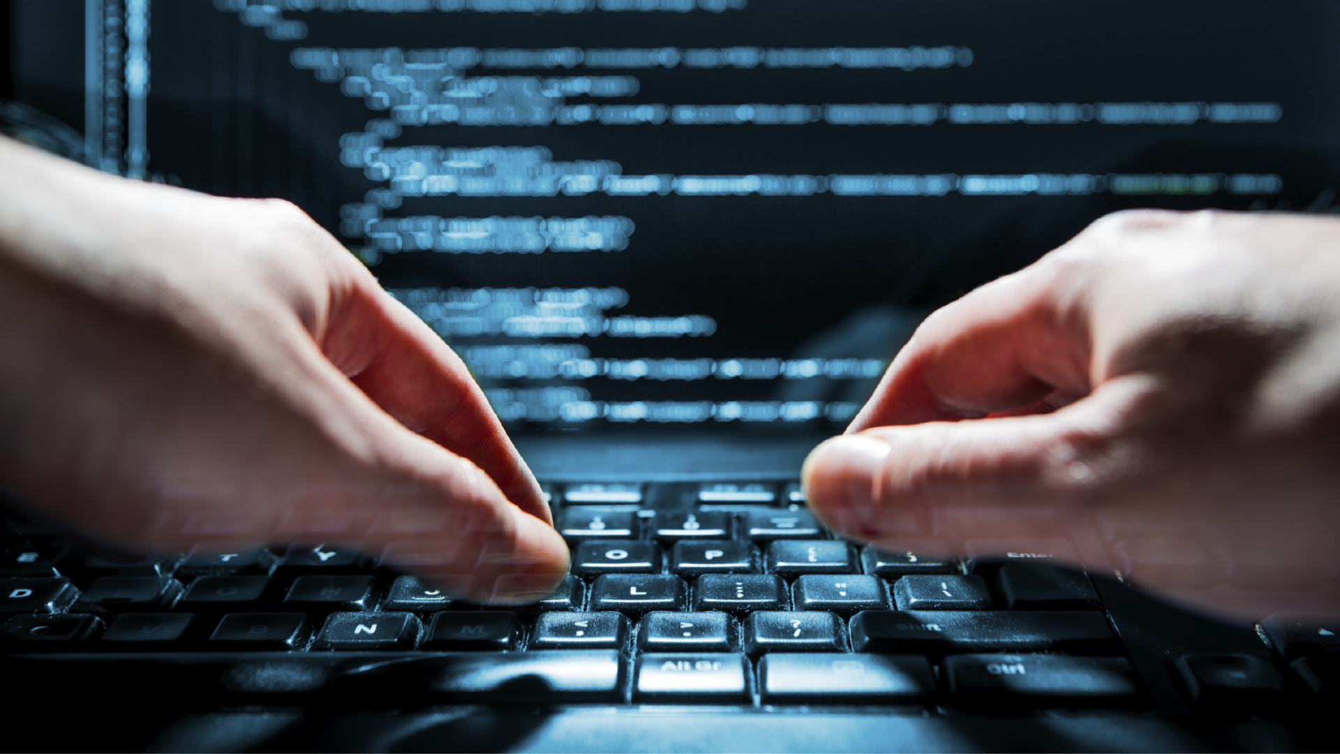 Hacker using laptop showing code on screen