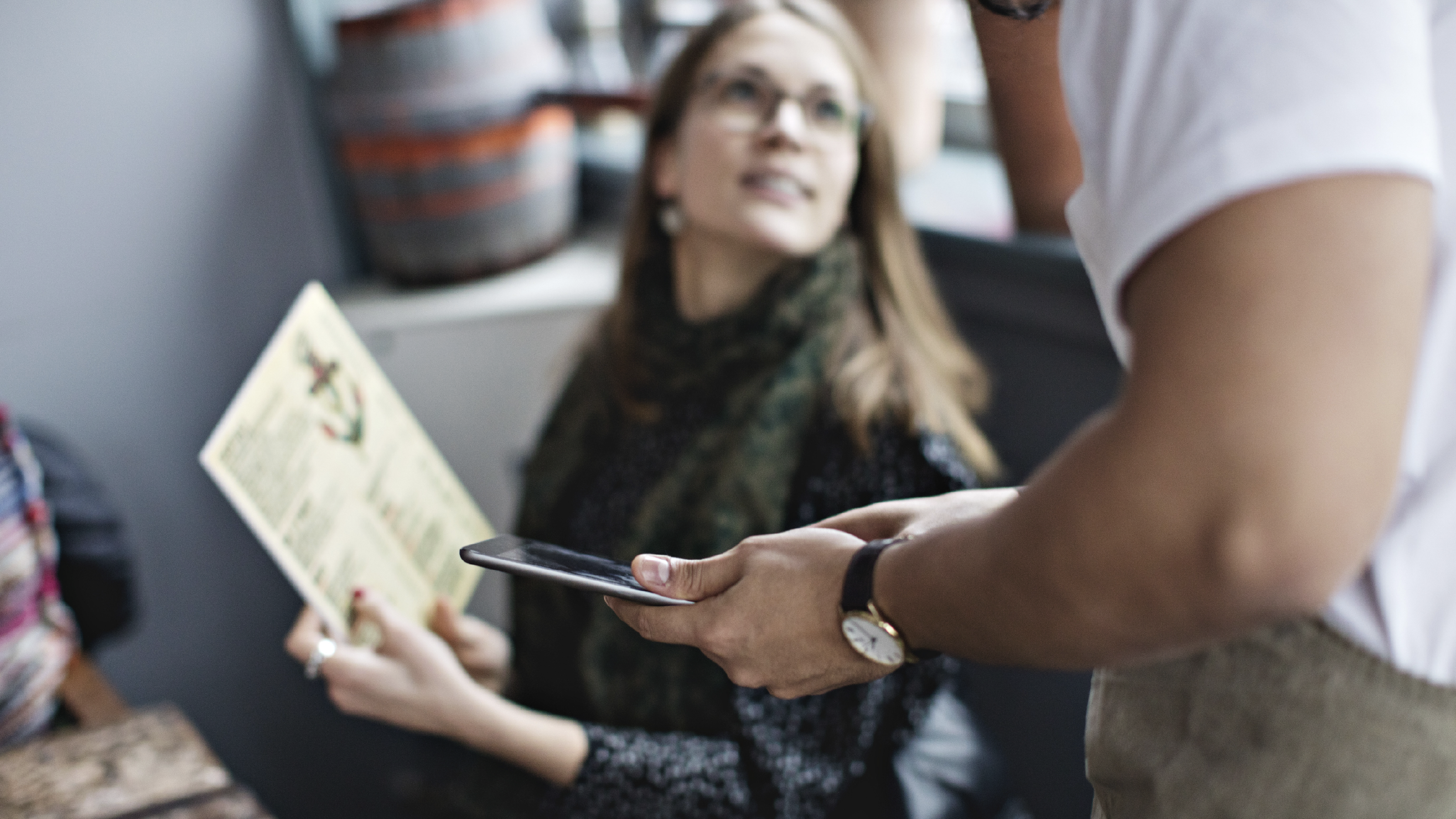 Customer asking for menu from waiter holding digital tablet at restaurant 