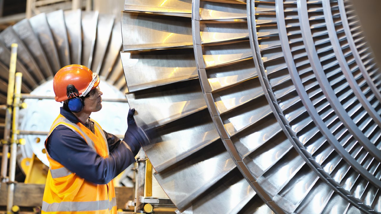 Worker inspects turbine in power station