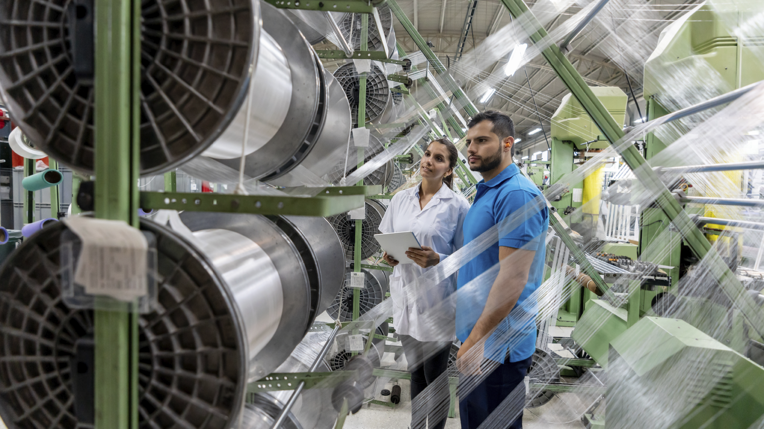 Workers at a factory looking at the operation of a machine