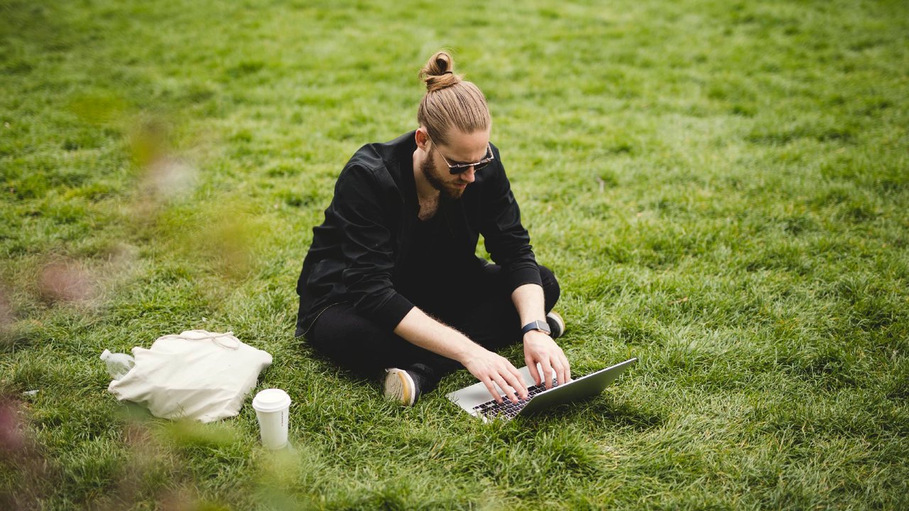 Man using a laptop in a park