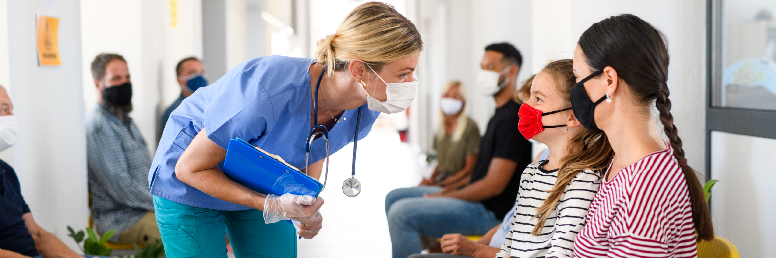 Infirmière et patients dans une salle d'attente portant un masque pour réduire la transmission du virus