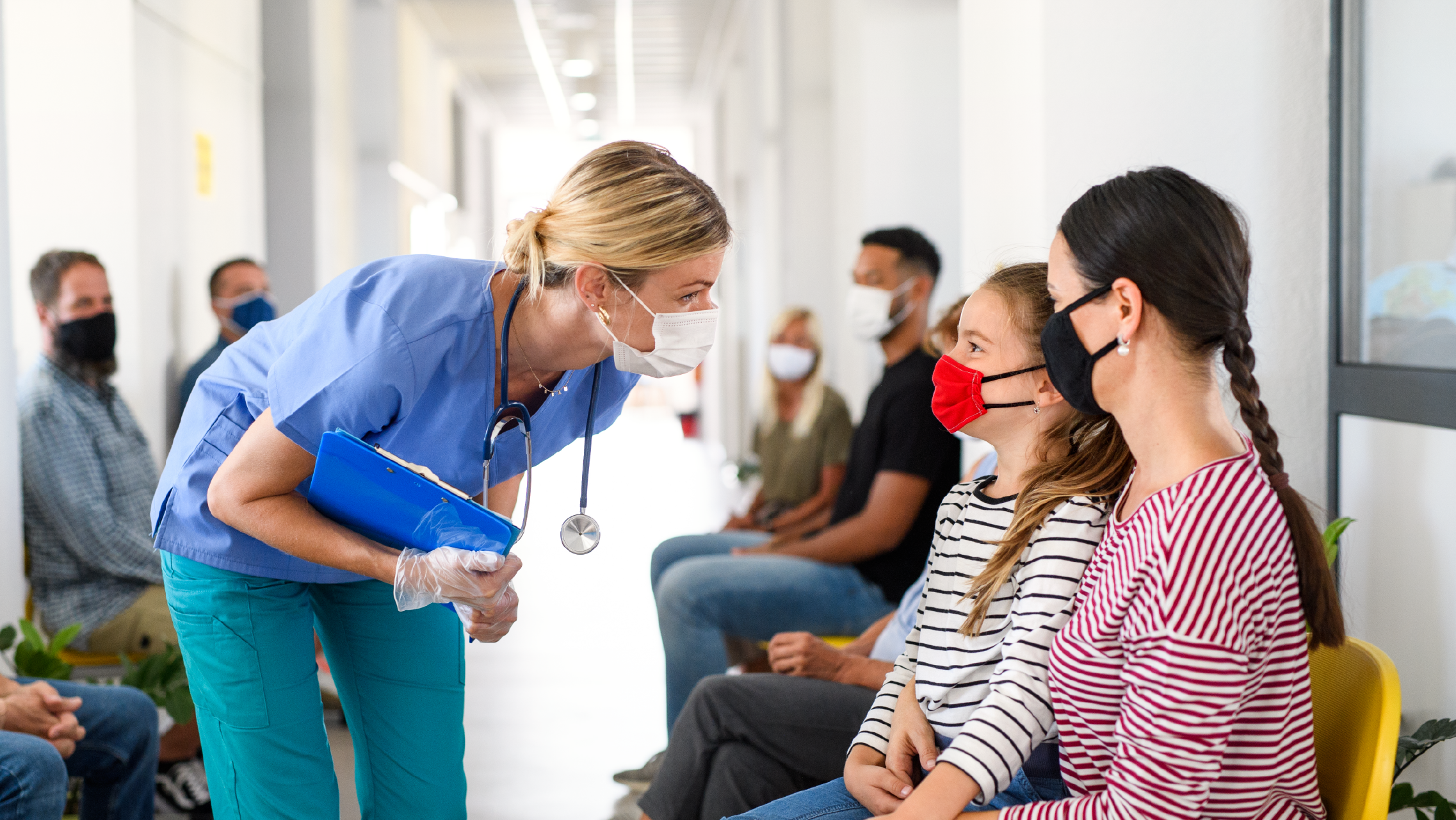Infirmière et patients dans une salle d'attente portant un masque pour réduire la transmission du virus