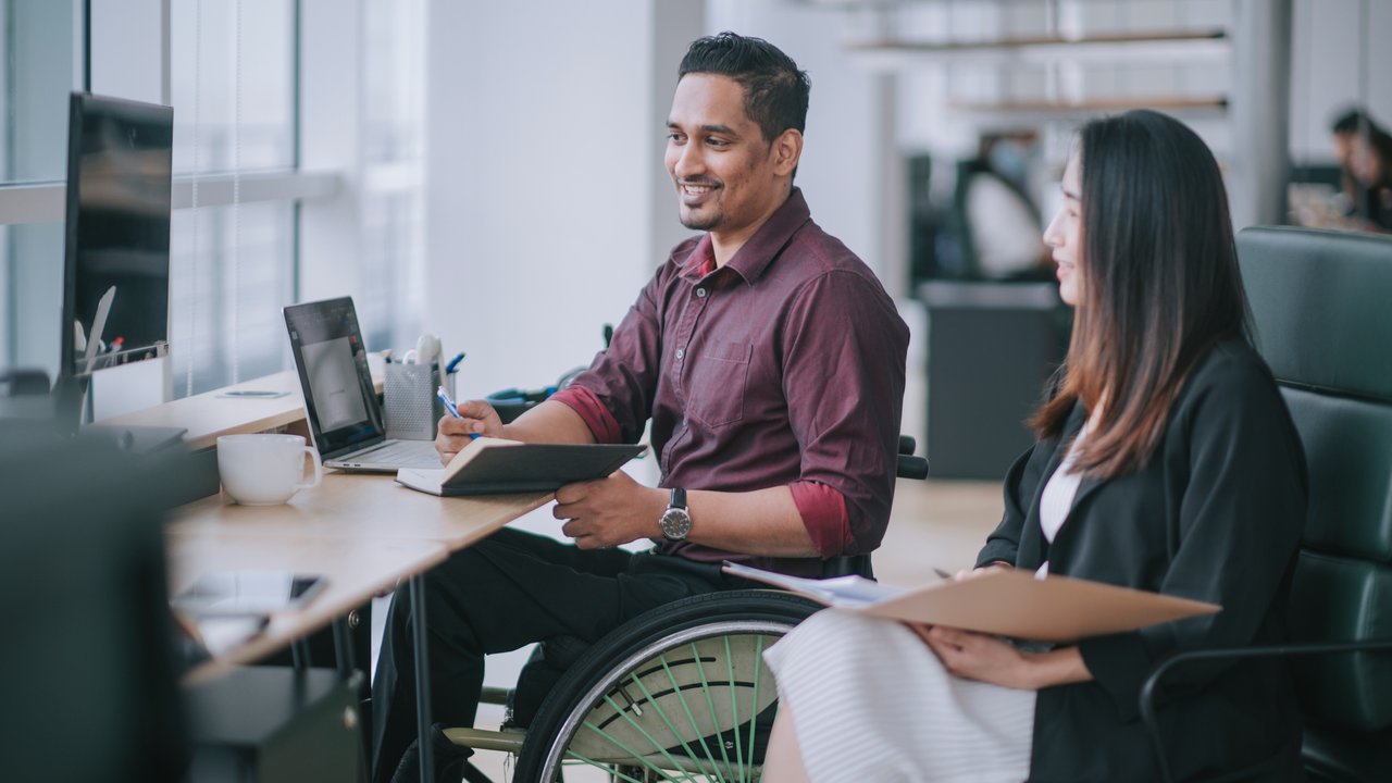 A stressed man using a laptop