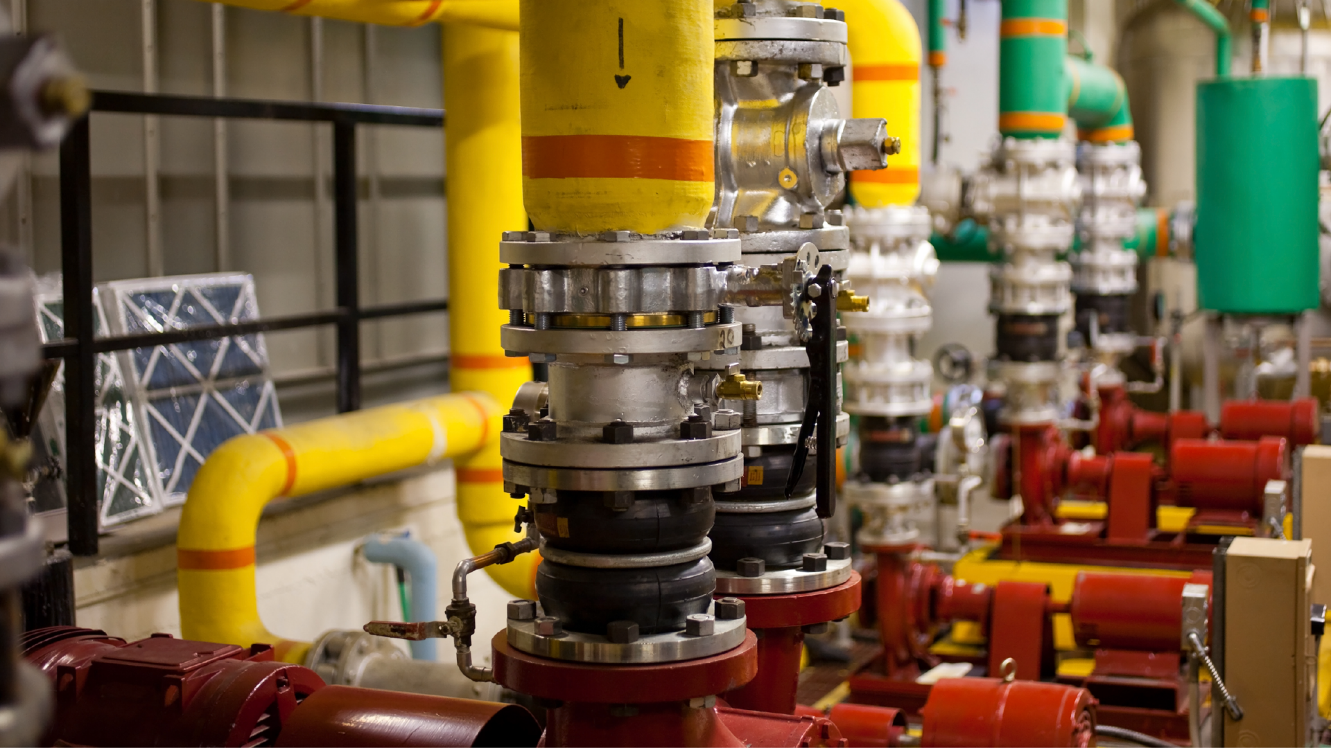 Multi-coloured pipes in a commercial boiler room