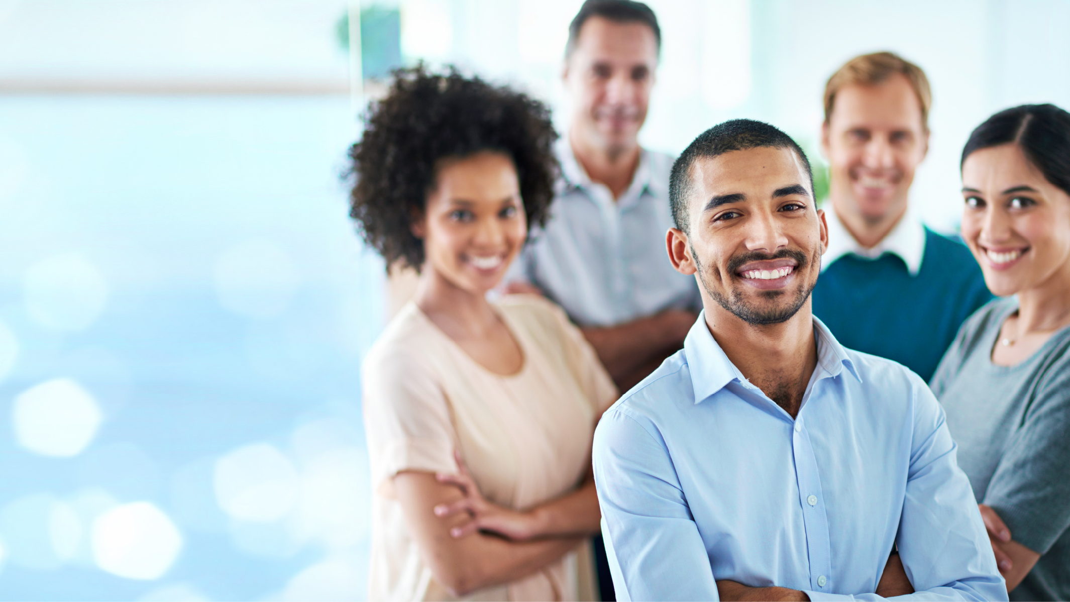 Un groupe composé de différents collègues debout dans leur bureau