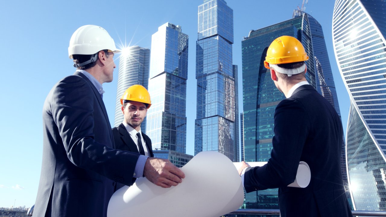 Building owners and engineers overlooking a construction site with builders insurance