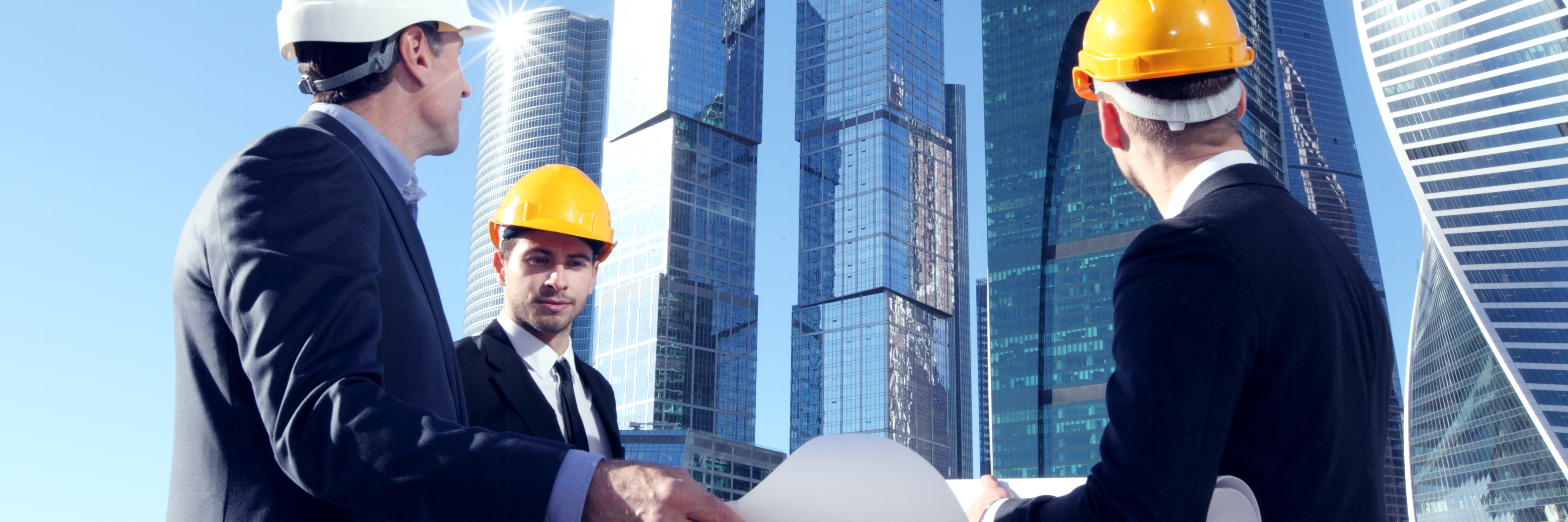 Building owners and engineers overlooking a construction site with builders insurance
