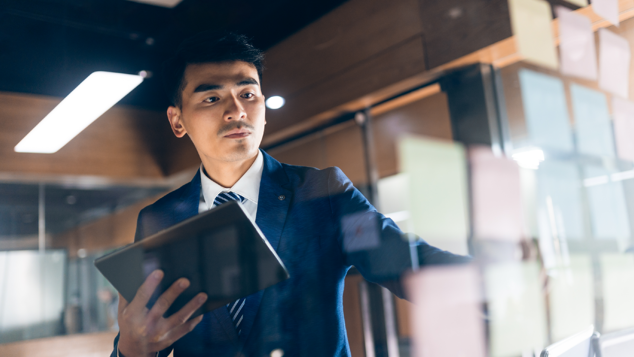 Businessman in a suit brainstorming using a tablet