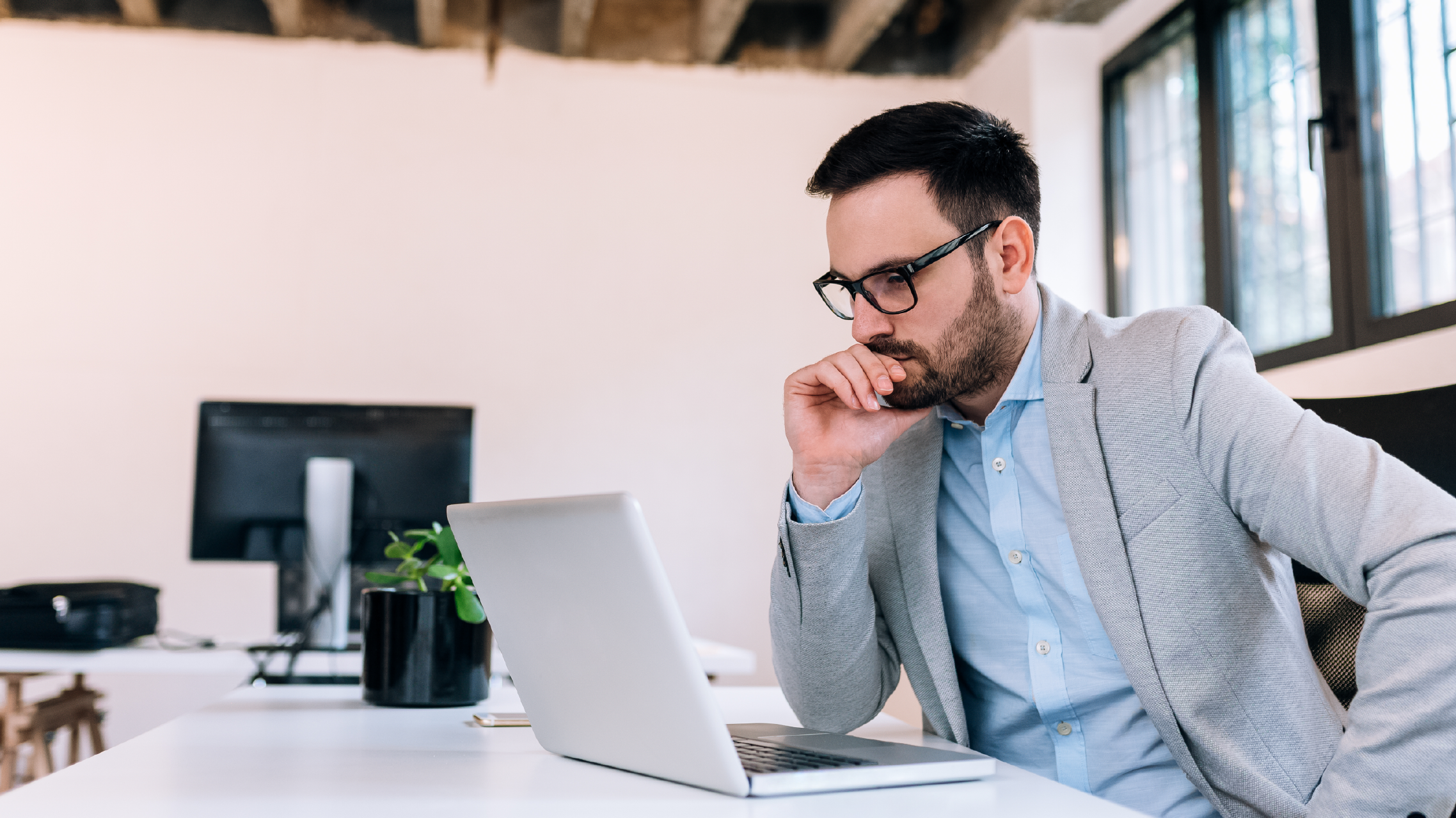 A person sitting at a desk at work, using a laptop