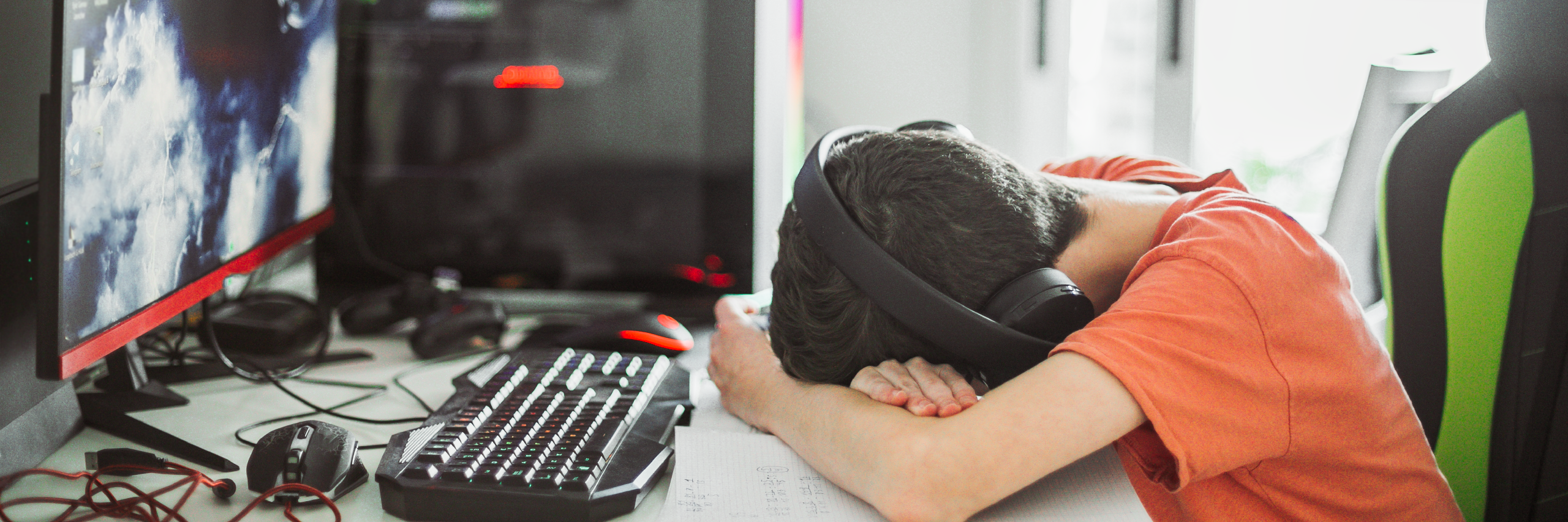 Un étudiant victime de cyber-intimidation stressé, assis à son bureau, la tête baissée devant sont ordinateur